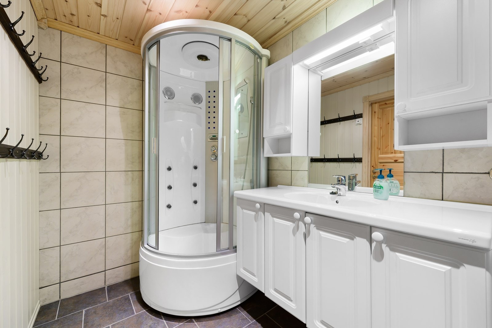 Badet har vegger av fliser og panel Galleribilde