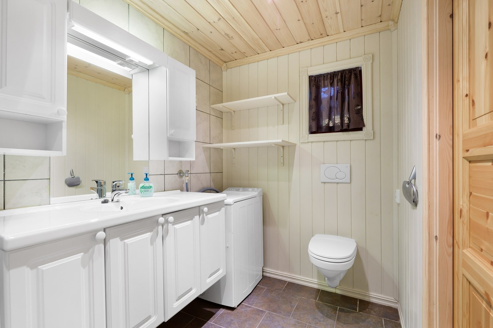 Badet har vegger av fliser og panel Galleribilde