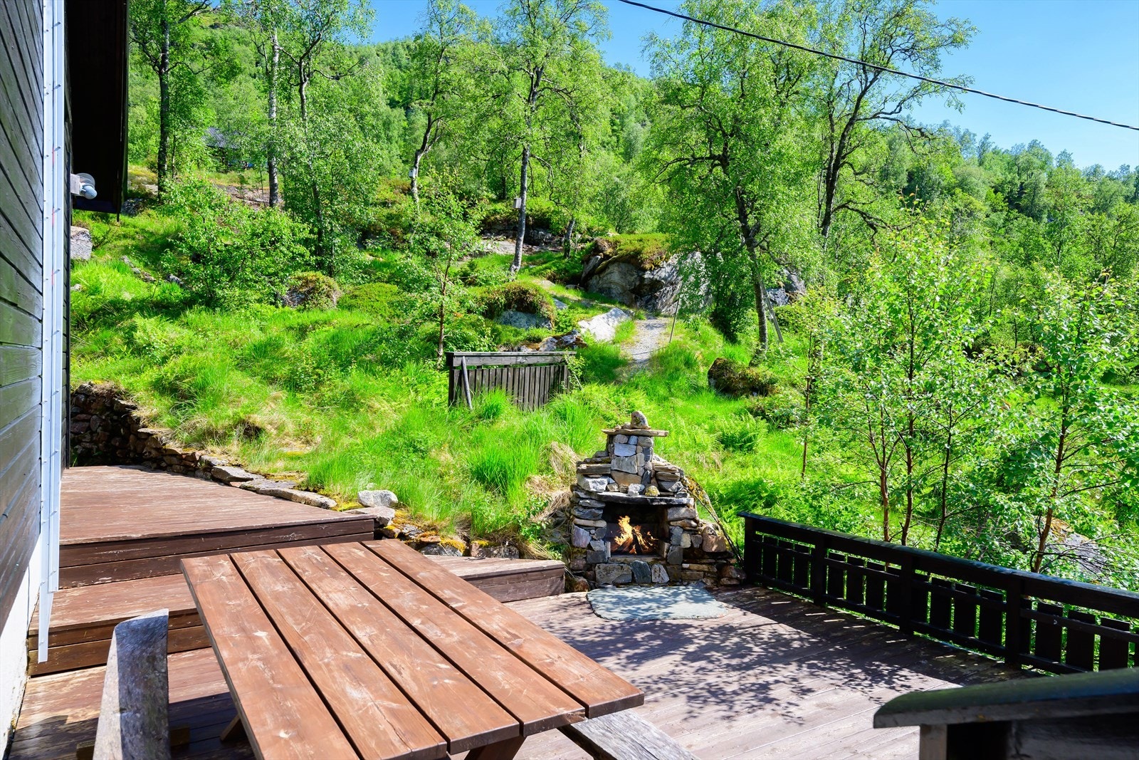 Åpen og flott terrasse med tillaget ildsted av steiner. Galleribilde