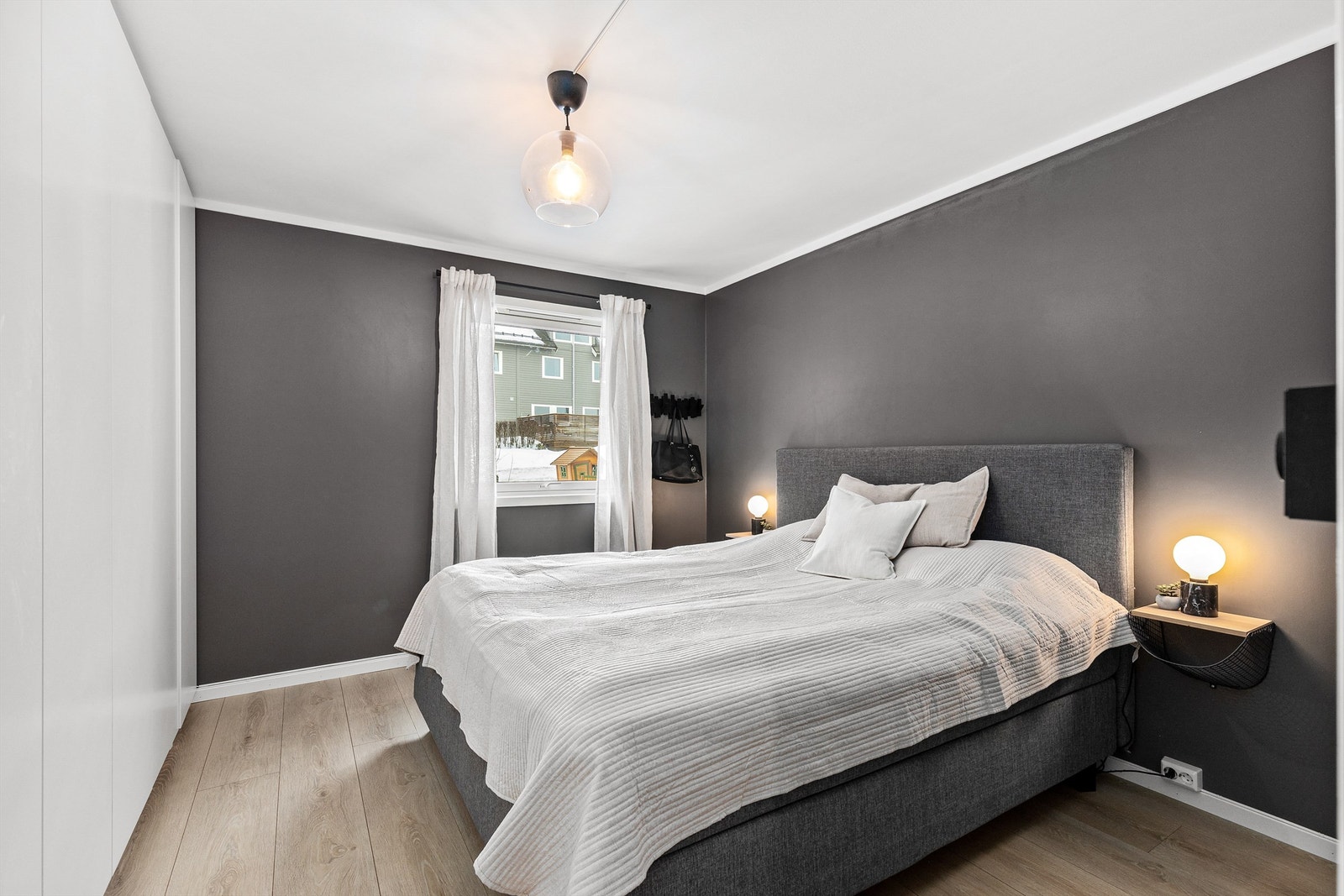 Hovedsoverommet er malt i en stilfull, nøytral nyanse, og er av god størrelse med plass til dobbeltseng, tilhørende nattbord og annet ønskelig møblement. Galleribilde