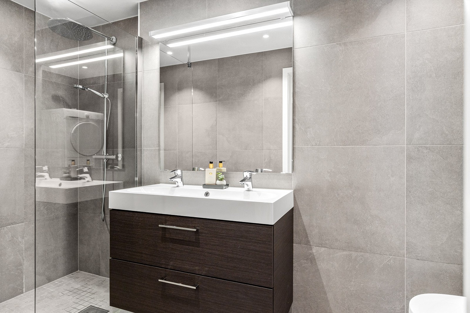 Badet er pent flislagt på gulv og vegger, med elektrisk gulvvarme. Galleribilde