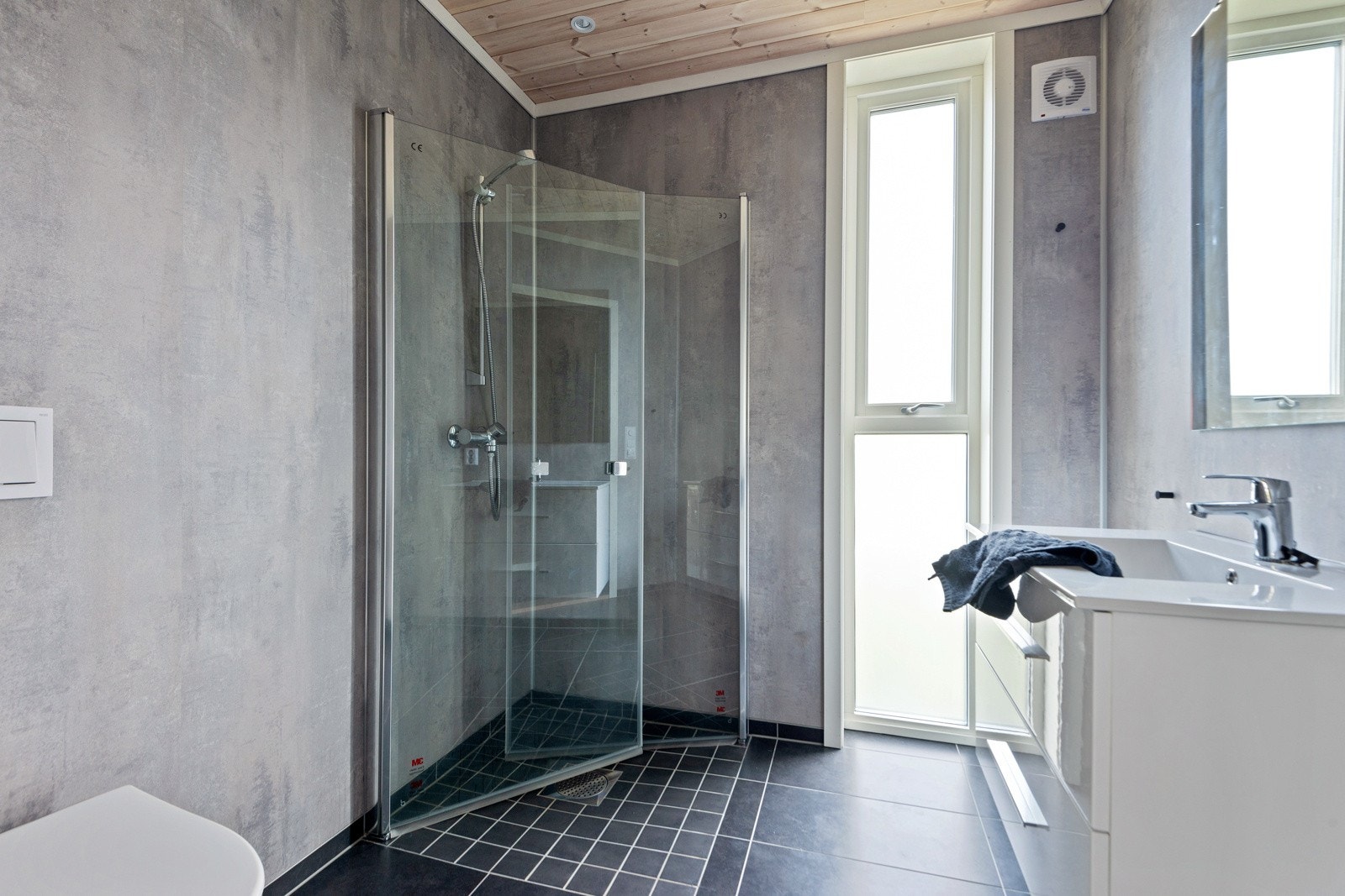 Badet er utstyrt med servant i møbel, toalett og dusjveggar. Det er oige vaskerom. Galleribilde