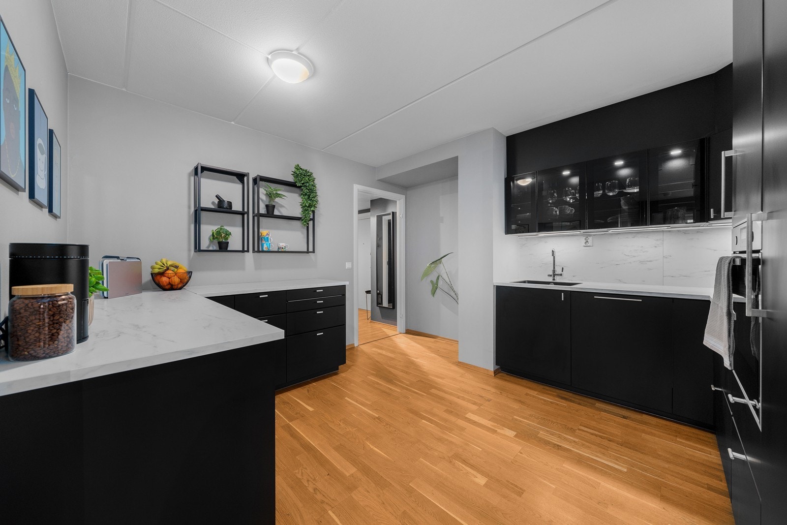 Kjøkkenet har en tidsriktig IKEA-innredning med slette fronter, samt laminat benkeplate med nedfelt oppvaskkum og 1-greps blandebatteri. Galleribilde