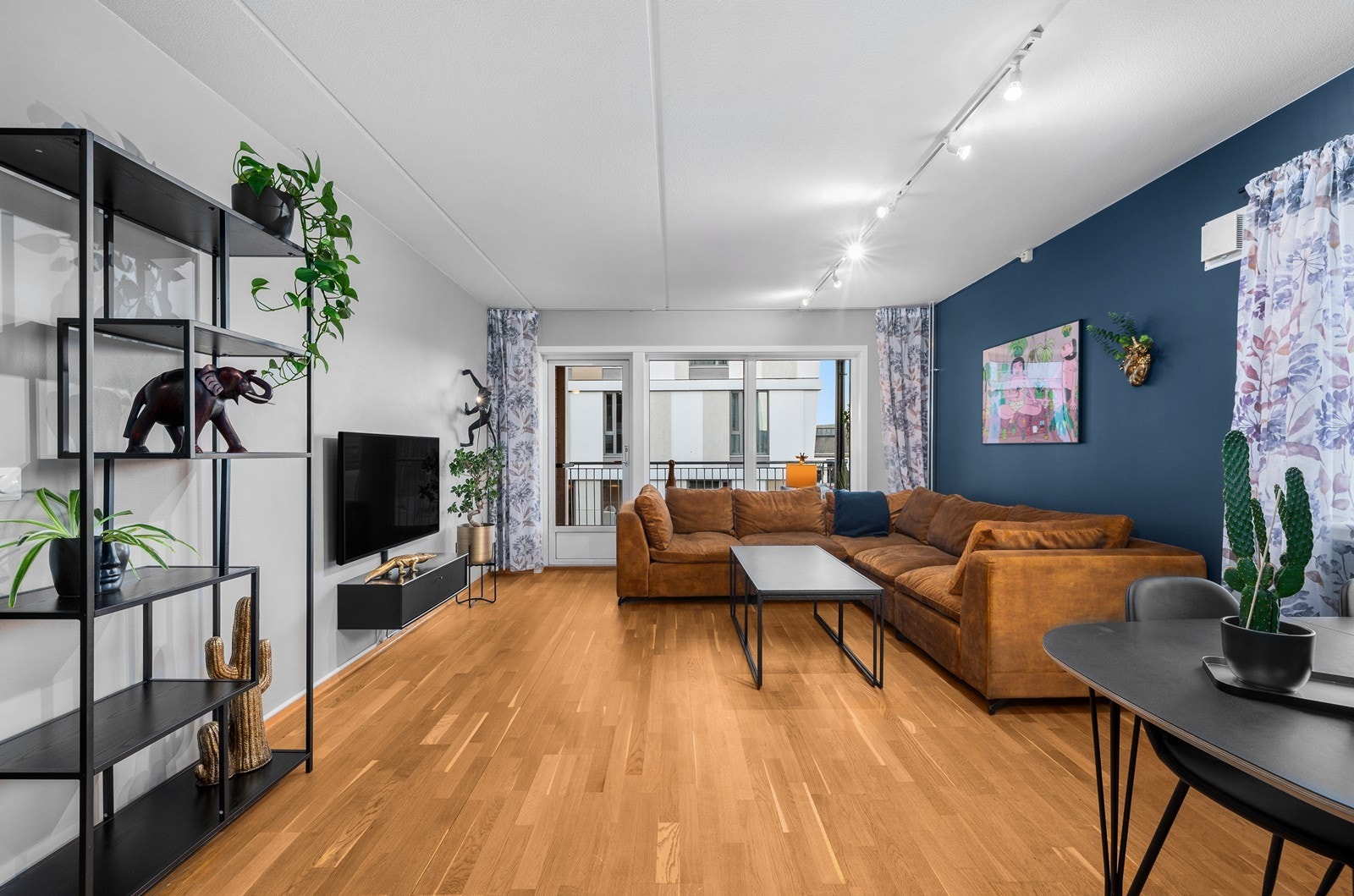 Boligen har en lys stue, med store vindusflater som slipper inn rikelig med naturlig lys fra to himmelretninger. Galleribilde