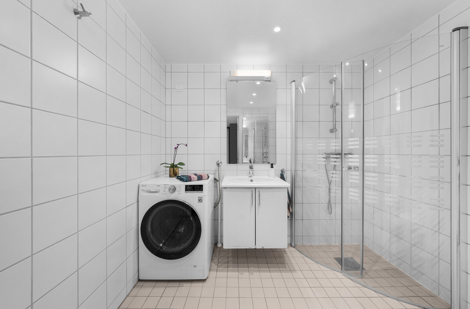 Fra gangen er det inngang til badet. Rommet har flislagt gulv med elektrisk gulvvarme, flislagte vegger og malt slett himling. Galleribilde