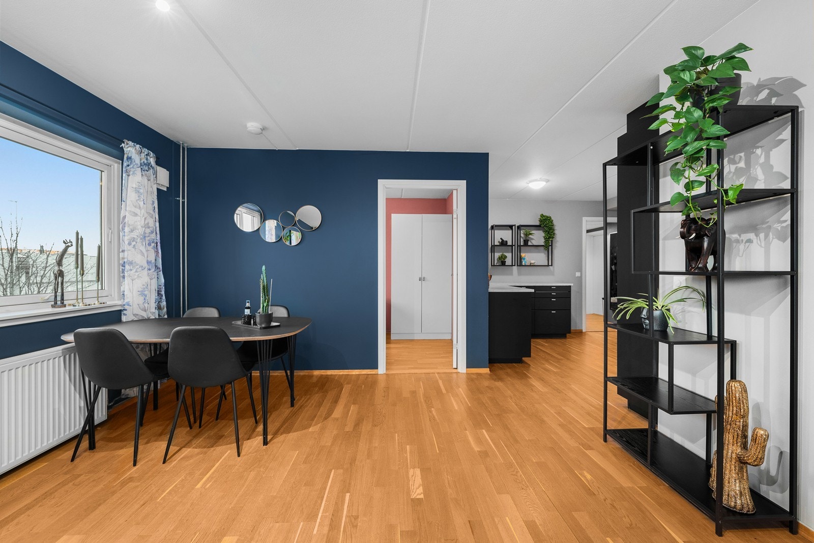 Leilighetens smarte planløsning skaper et naturlig skille mellom stue og kjøkken, selv om rommene er i åpen og sosial løsning. Galleribilde