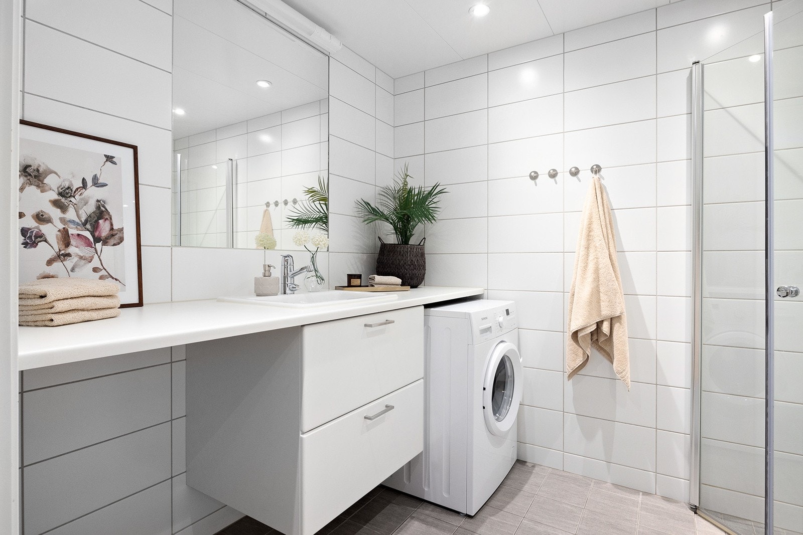 Flott flislagt bad med varme i gulv og platehimling med downlights. Galleribilde