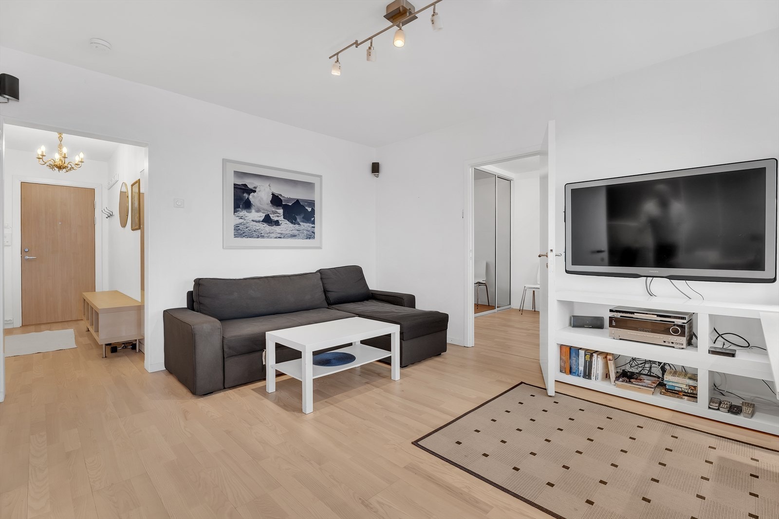 Romslig stue med parkett på gulv, malte vegger og malt tak. Galleribilde