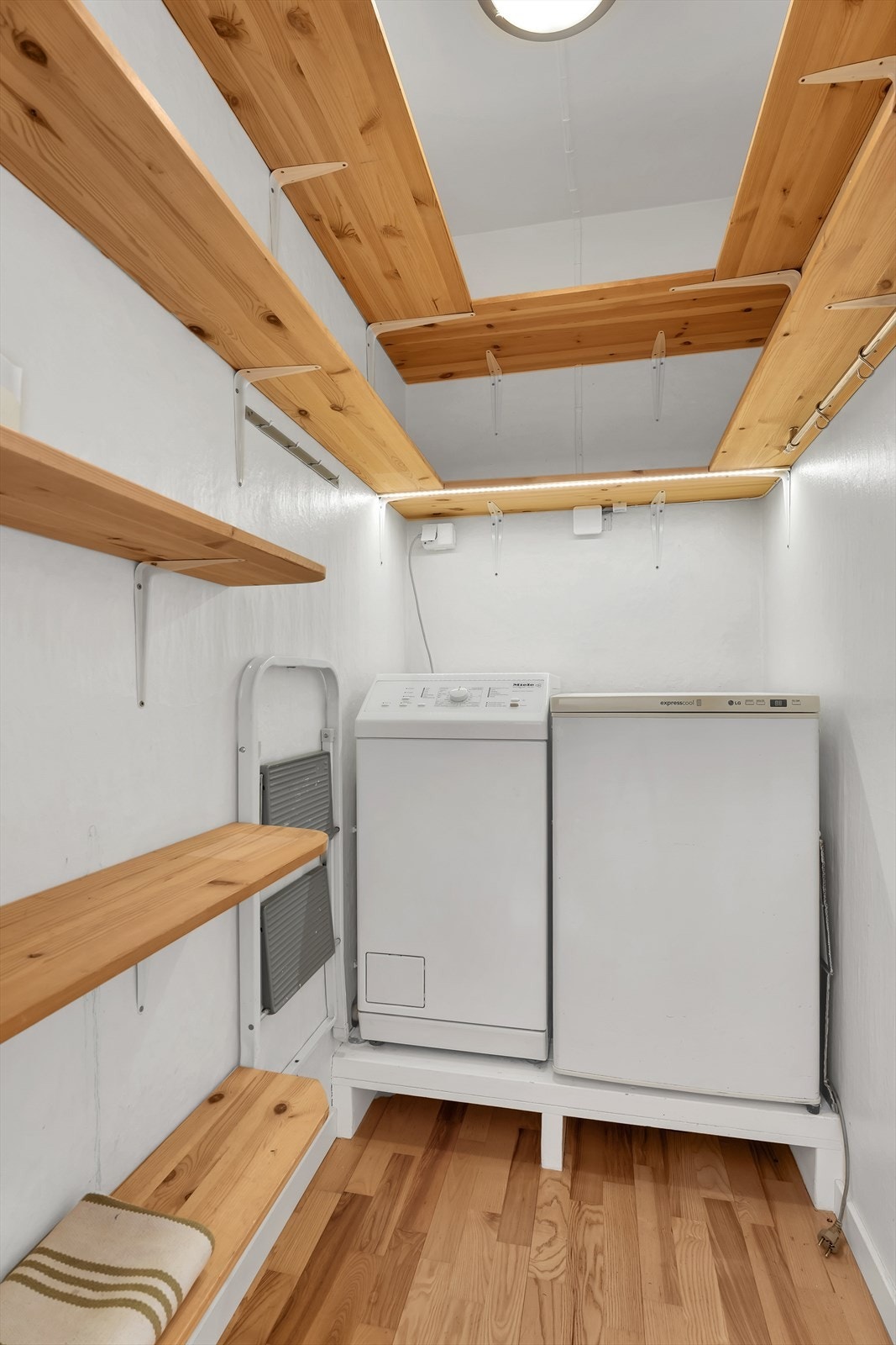 Bod med parkett på gulv, malte vegger og malt tak. Det er montert hyller samt opplegg for vaskemaskin. Vaskemaskin og fryseskap i boden følger. Galleribilde