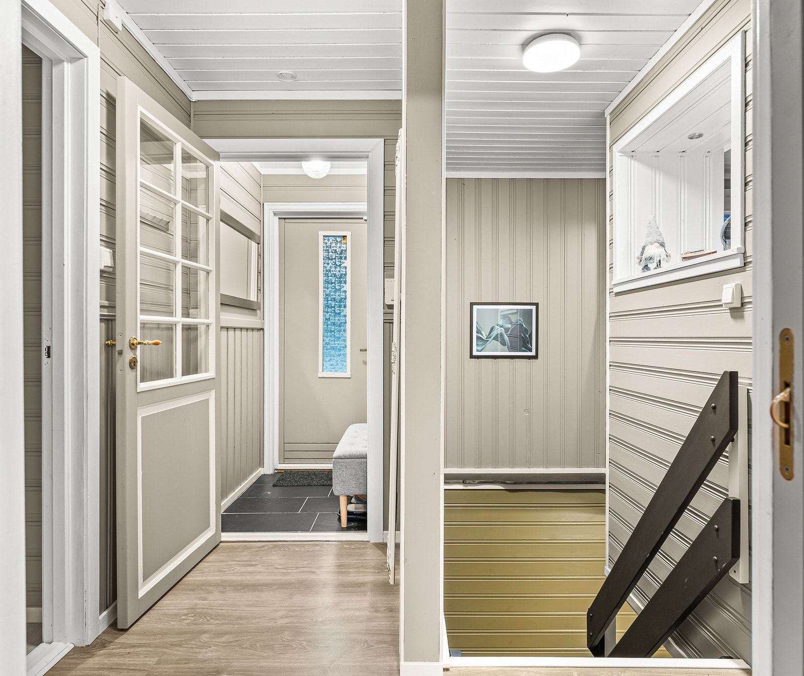 Velkommen inn! Vindfanget har praktiske fliser på gulvet og malt panel på vegger og i taket, og gir en lun start på boligen Galleribilde