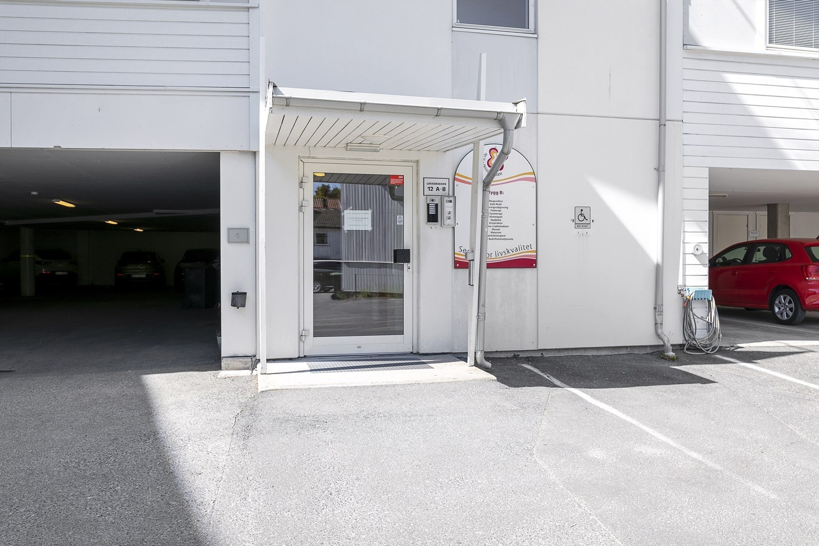 Adkomst til lokalet fra parkeringsplass via dør til heis og trapp til enhetens inngangsdør. Galleribilde