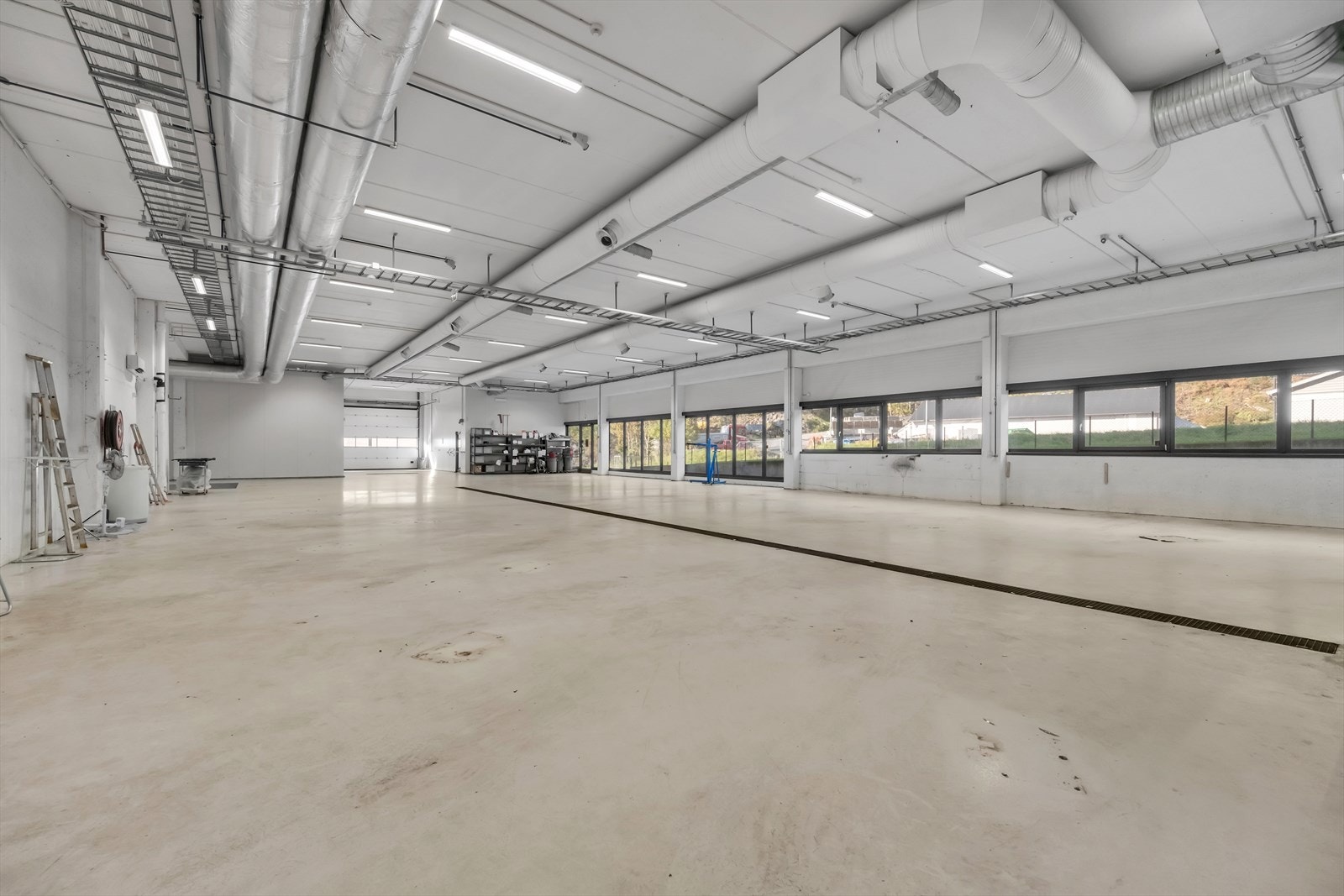 1 etasje med port og store vindusflater, midtmontert sluk Galleribilde