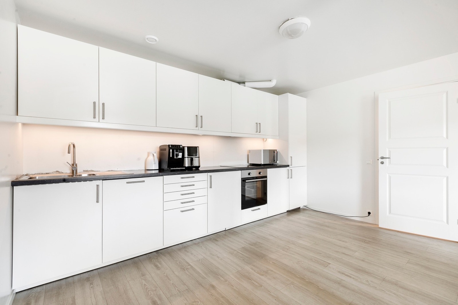 Lyst kjøkken med integrerte hvitevarer. Galleribilde