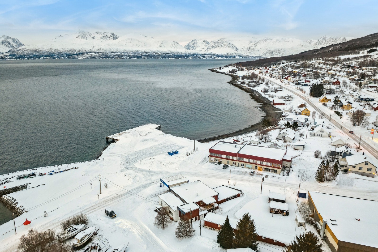 Drone av området. E6 er likeved eiendommen som går retning nordover mot Storslett som kjent tettsted i Nord-Troms. Eiendommen er nærmeste nabo med Coop Extra Olderdalen til høyre for bilde. Galleribilde