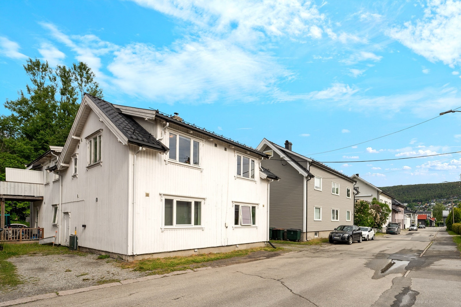 Disponibel parkeringsplass med el-billader langs husveggen Galleribilde