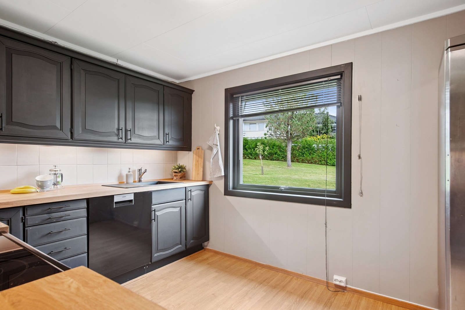Vinduet gir godt med naturlig lys til arbeidsflaten på kjøkkenet og utsyn mot hagen. Galleribilde