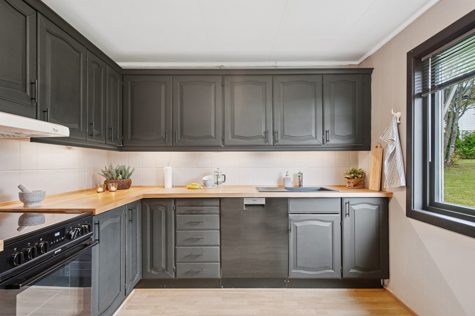 Kjøkkenet har en funksjonell hjørneløsning med rikelig skap- og benkeplass. Galleribilde