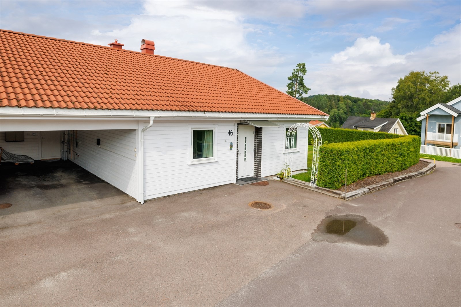 Asfaltert gårdsplass og parkering i carport. Galleribilde