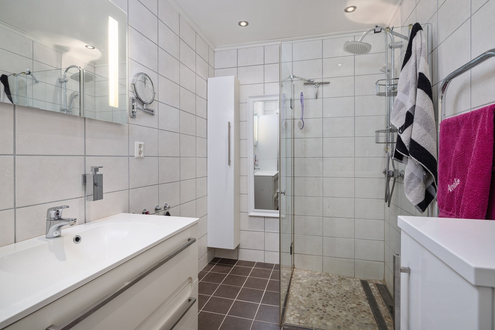 Badet har innredning med heldekkende servant, speil med integrert belysning, dusjhjørne og toalett. Galleribilde