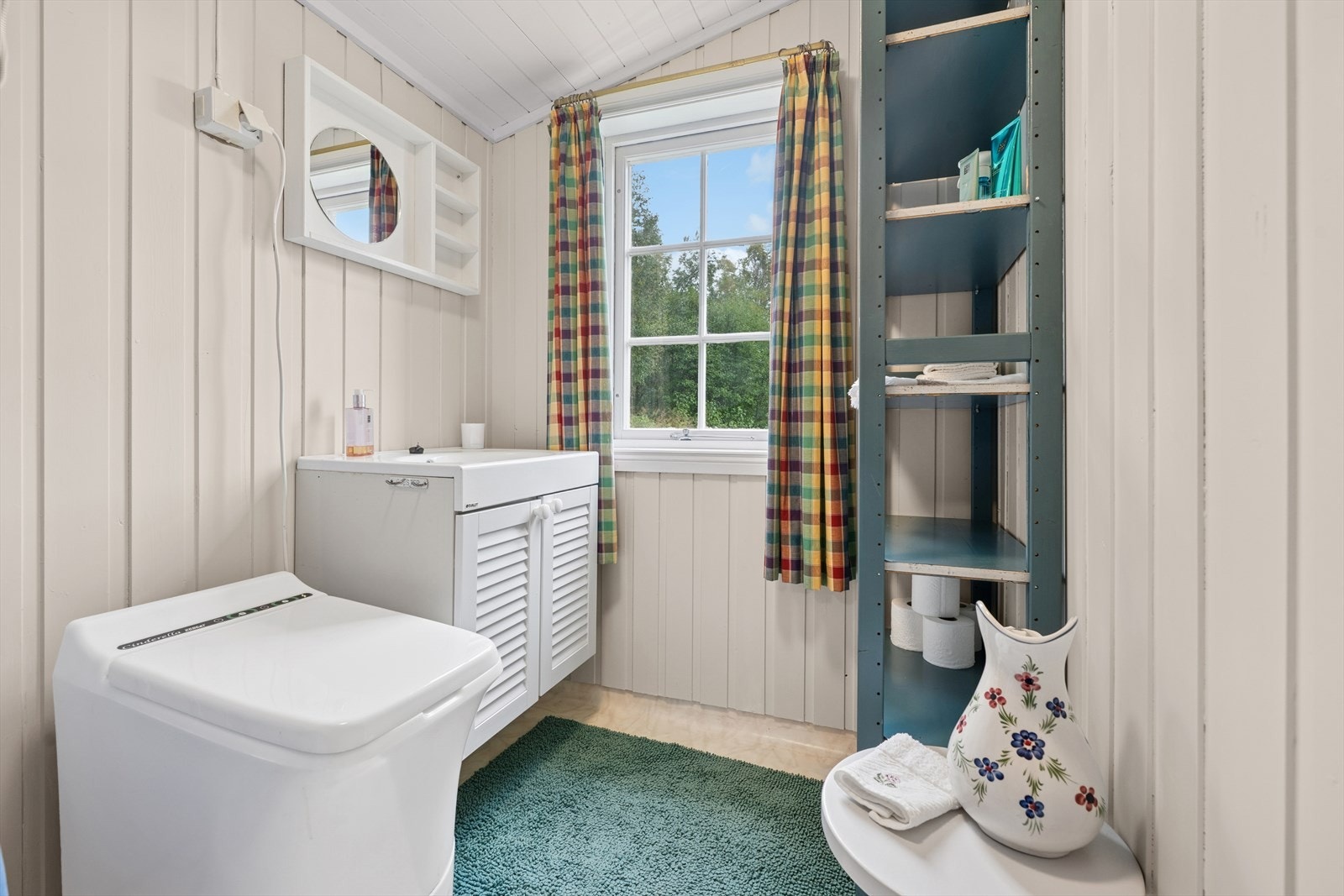 Bad med dusjkar med forheng, lys baderomsinnredning og Cinderella forbrenningstoalett. Galleribilde