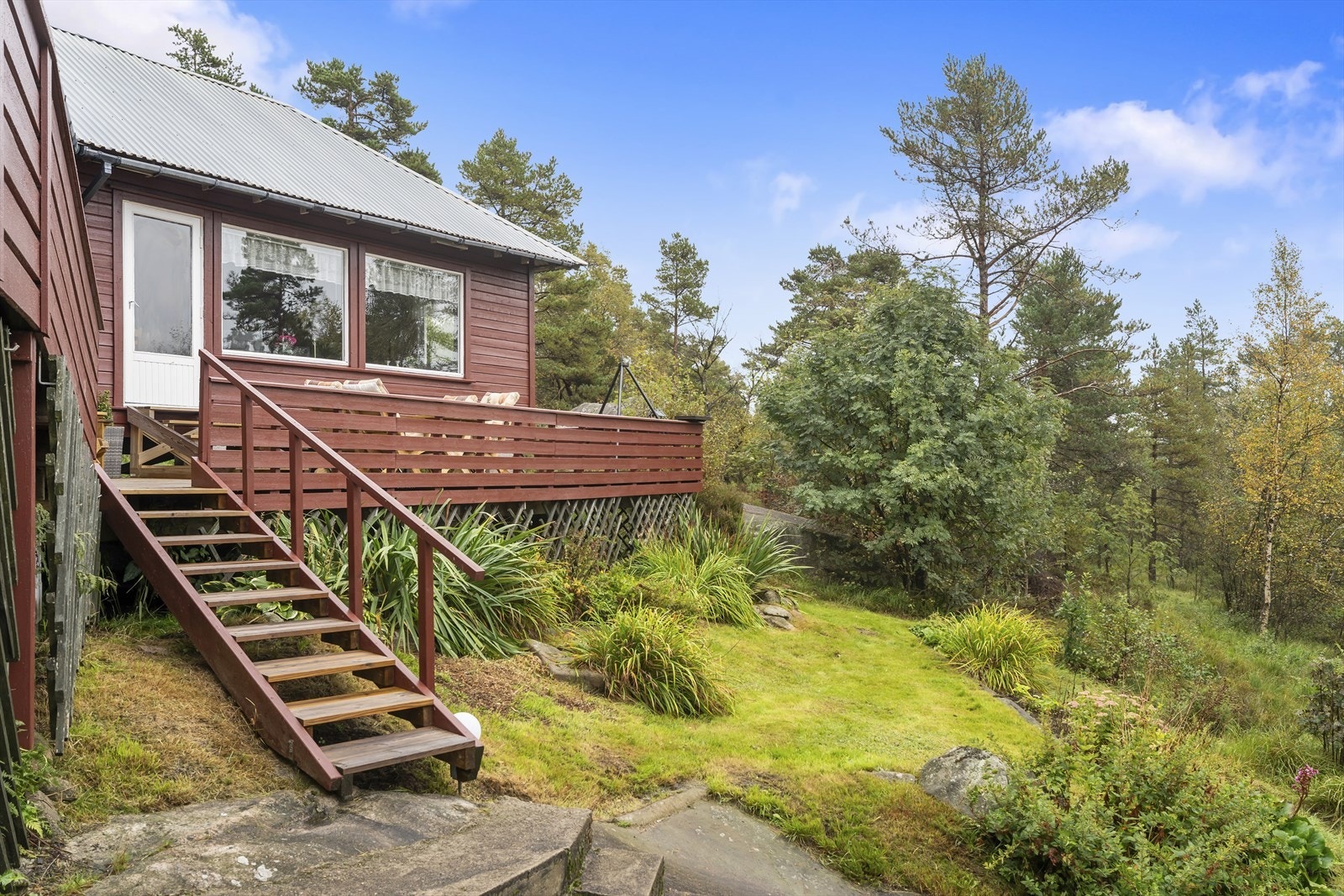 Hytten ligger i frodige omgivelser og har terrasser hvor solen kan nytes. Galleribilde