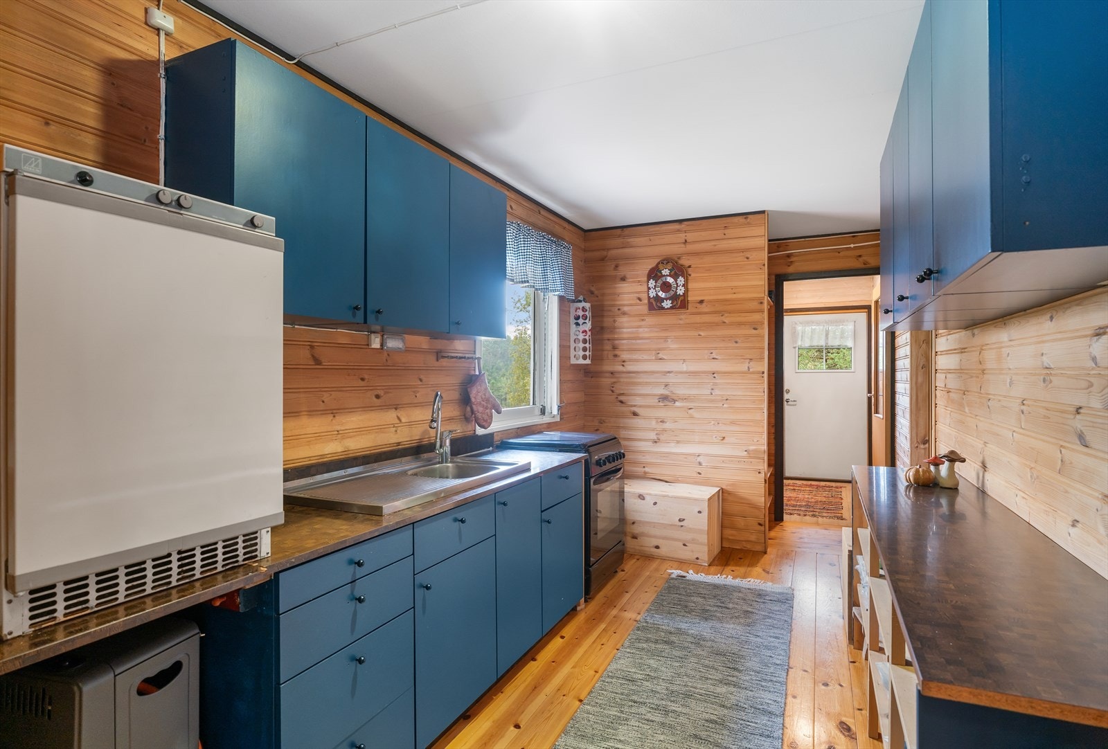 Fra gangen kommer vi inn til kjøkken som er utstyrt med kjøkkeninnredning og komfyr og kjøleskap på gass. Galleribilde