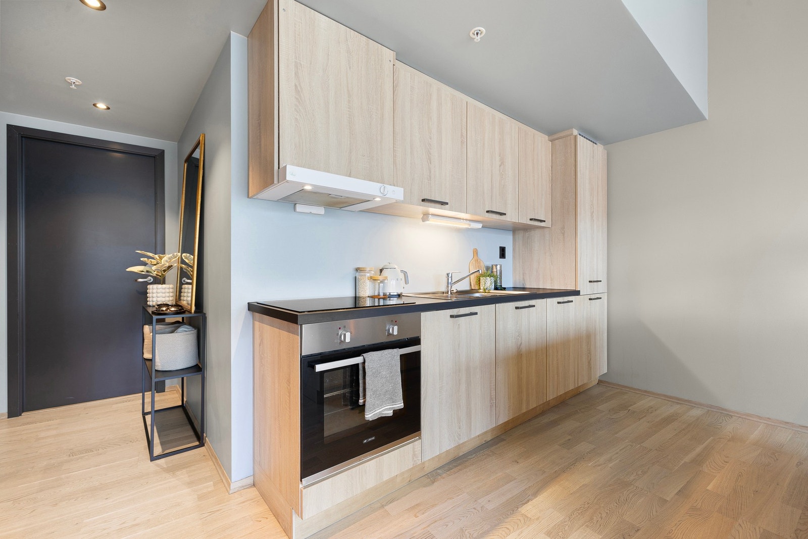 Legg merke til de sorte detaljene som er gjennomgående i leiligheten. Sort benkeplate, sorte dørhåndtak og sorte stikkontakter skaper en fin kontrast til det øvrige lyse. Galleribilde