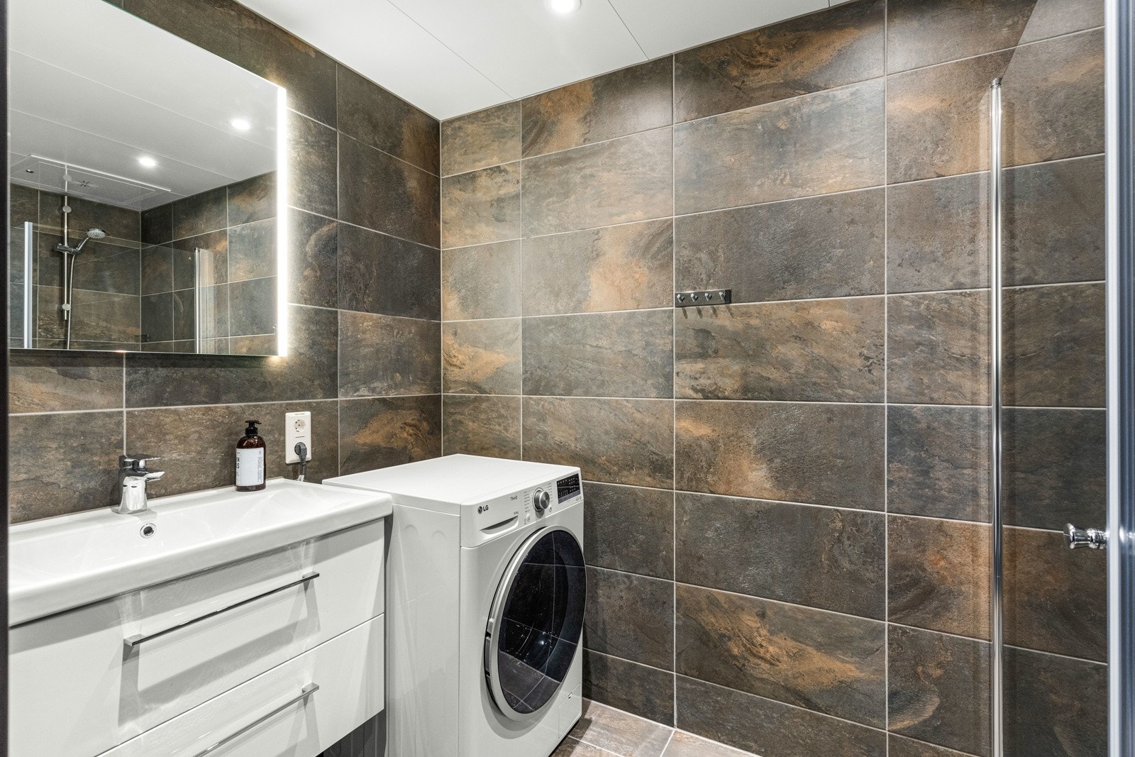 Baderom nr. 2. Badet har et flott lyst servant og vegghengt speil med belysning. Galleribilde