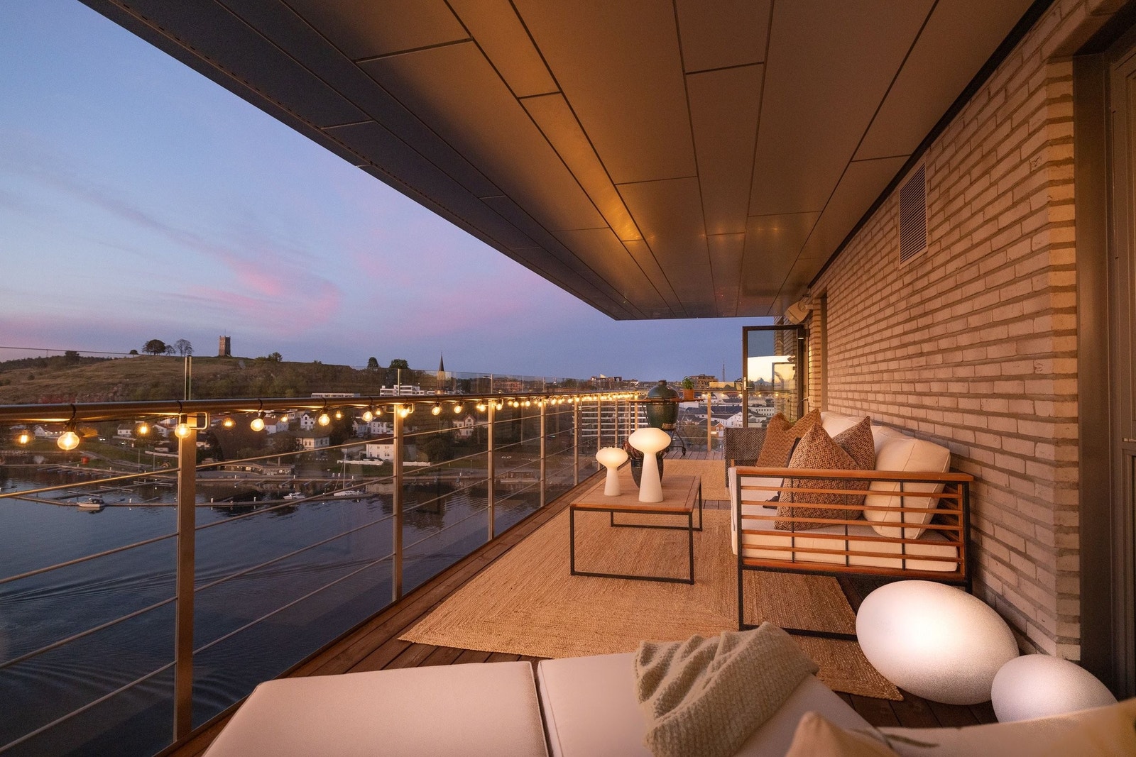 Fra terrassen ser du fjorden bade i kveldssol, mens Slottsfjellet tennes opp i det fjerne – en utsikt som gjør hver kveld til noe helt spesielt Galleribilde