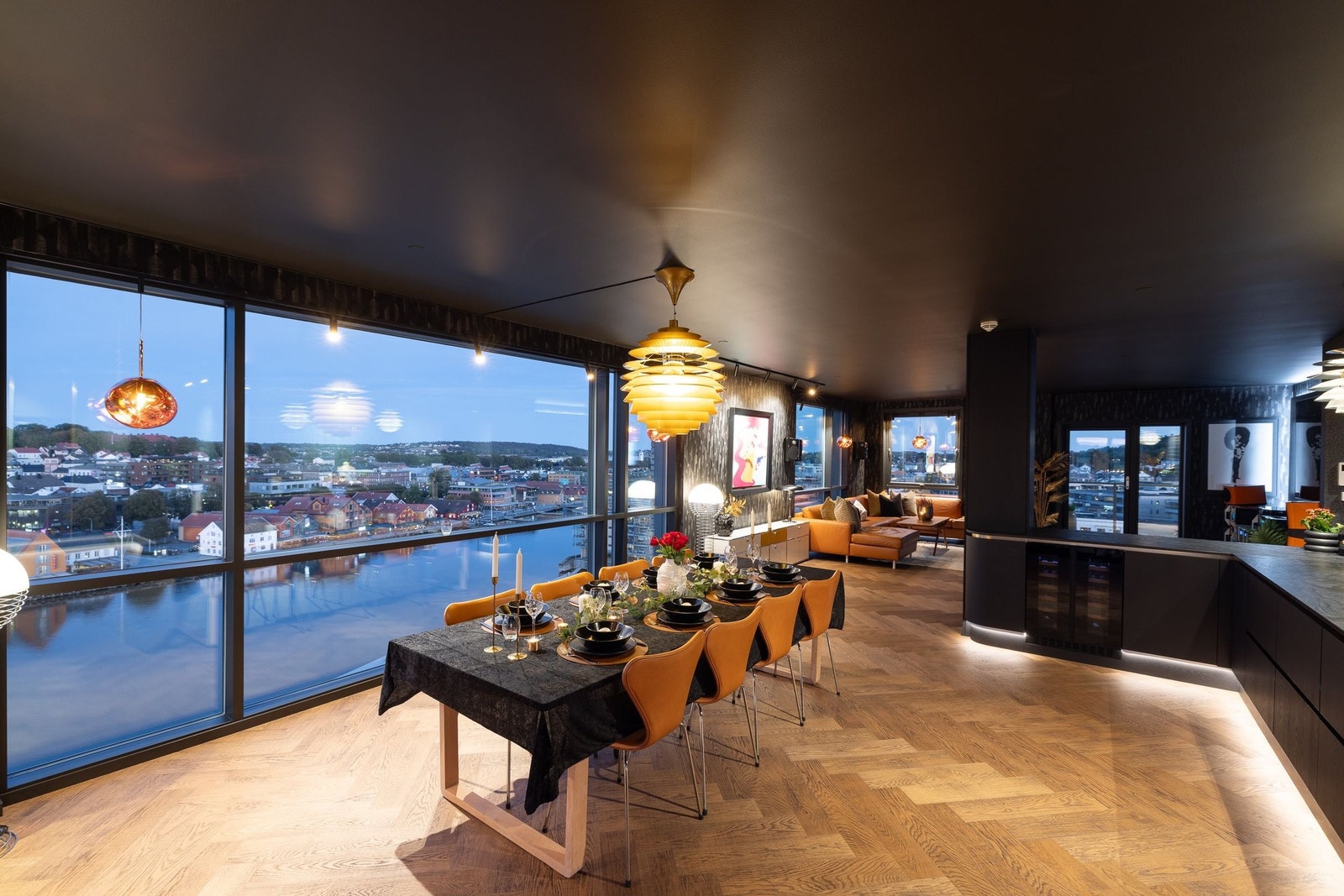 En åpen planløsning som flyter sømløst mellom kjøkken, spiseplass og stue Galleribilde