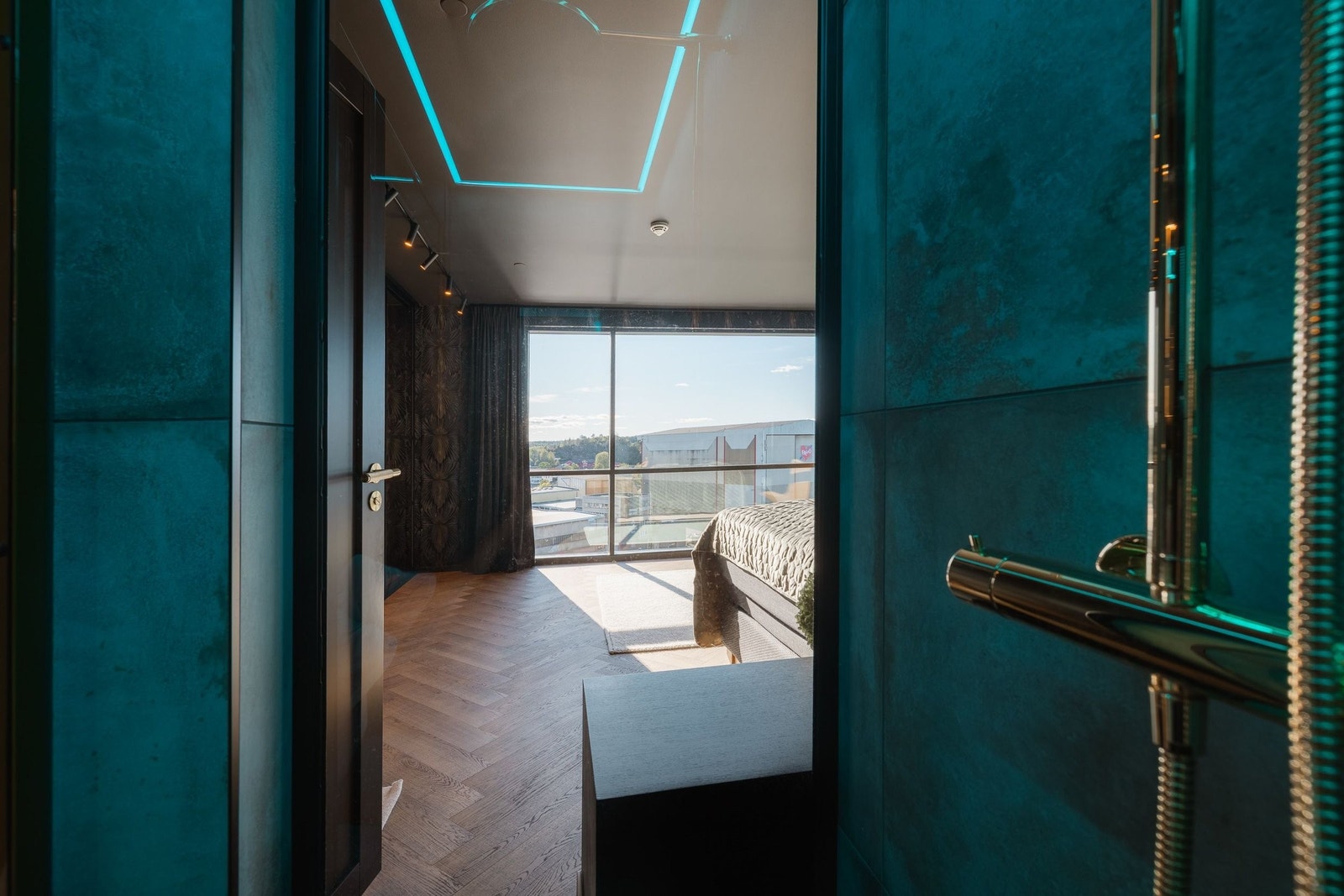 Fra hovedbadet ser du rett inn i hovedsoverommet, der lys og utsikt setter rammen for en suite som føles både generøs og gjennomført. Materialvalgene binder rommene sammen og gir en følelse av helhet Galleribilde