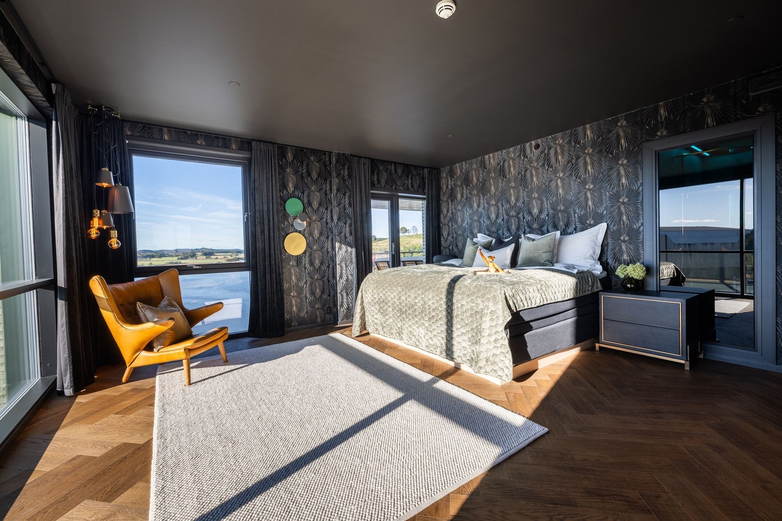 Hovedsoverommet er en suite i ordets rette forstand – med panoramautsikt fra to sider, eksklusive materialvalg og direkte tilgang til terrassen. Her våkner du til fjorden som bakteppe, mens interiøret byr på en lun og sofistikert atmosfære Galleribilde