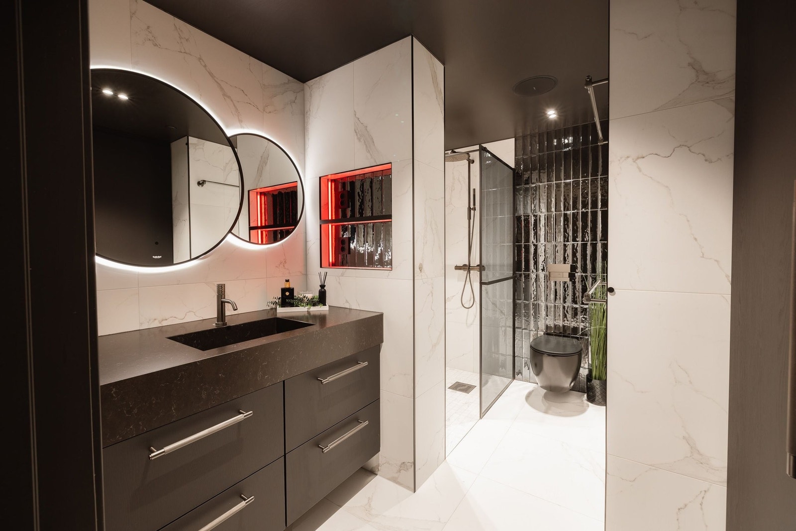 Bad med troperegnsdusj, plassbygde skap med opplegg til vaskemaskin og tørketrommel, samt eksklusivt flisevalg Galleribilde