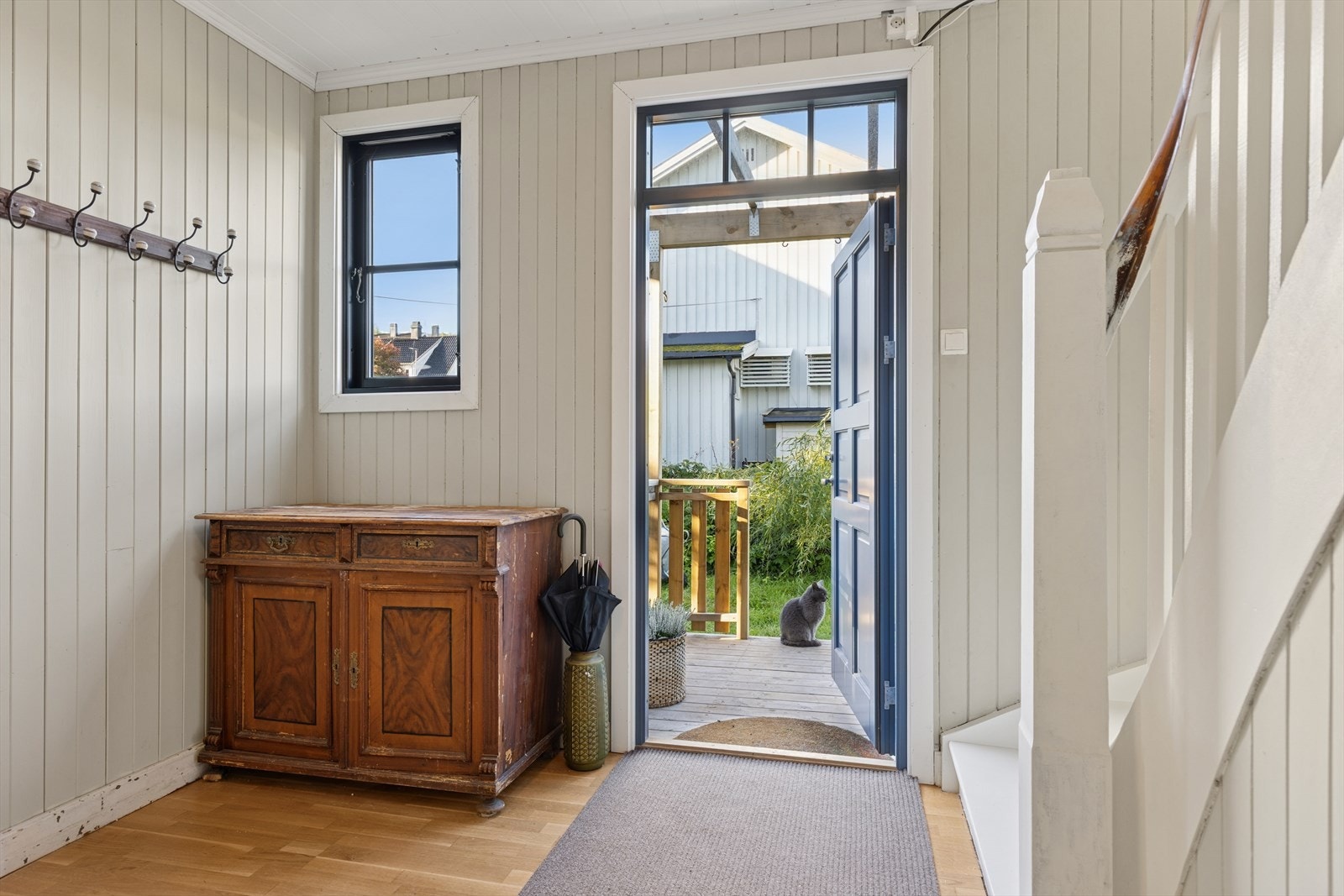 En nyere ytterdør med seks speil og overlys slipper inn dagslys og rammer inn inngangspartiet med klassisk eleganse. Galleribilde