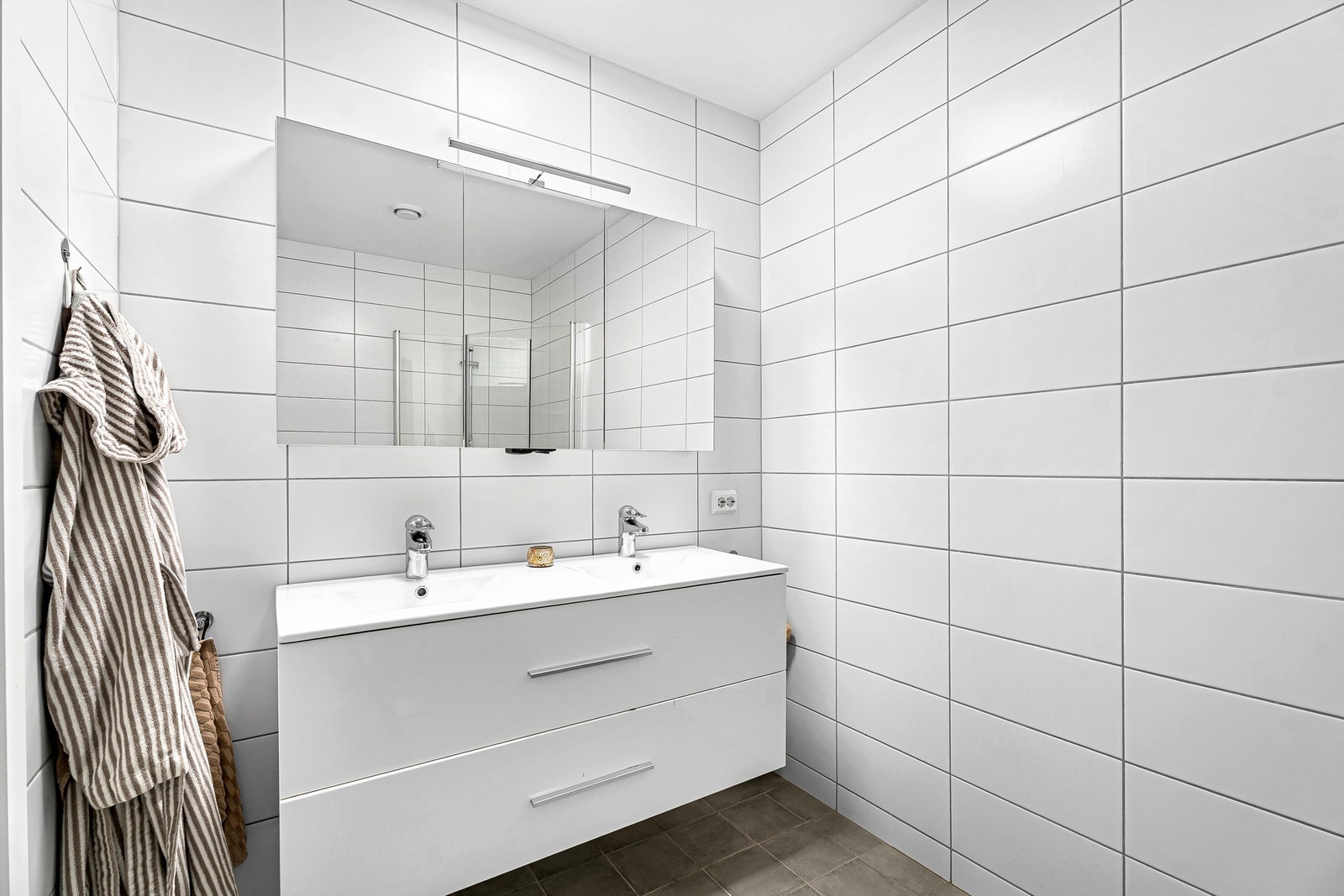 Bad med romslig innredning, dobbel vask og god oppbevaringsplass i speilskap Galleribilde