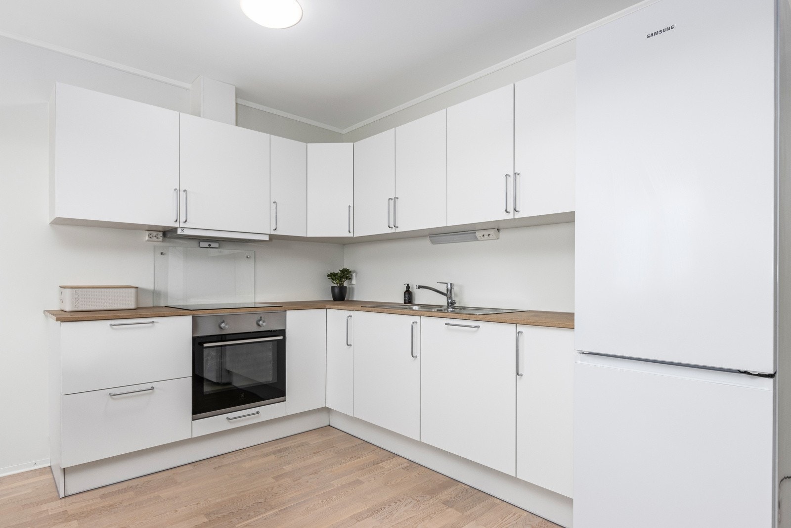 Kjøkken fra JKE Design med integrert induksjonstopp, komfyr, oppvaskmaskin og mekanisk avtrekk Galleribilde