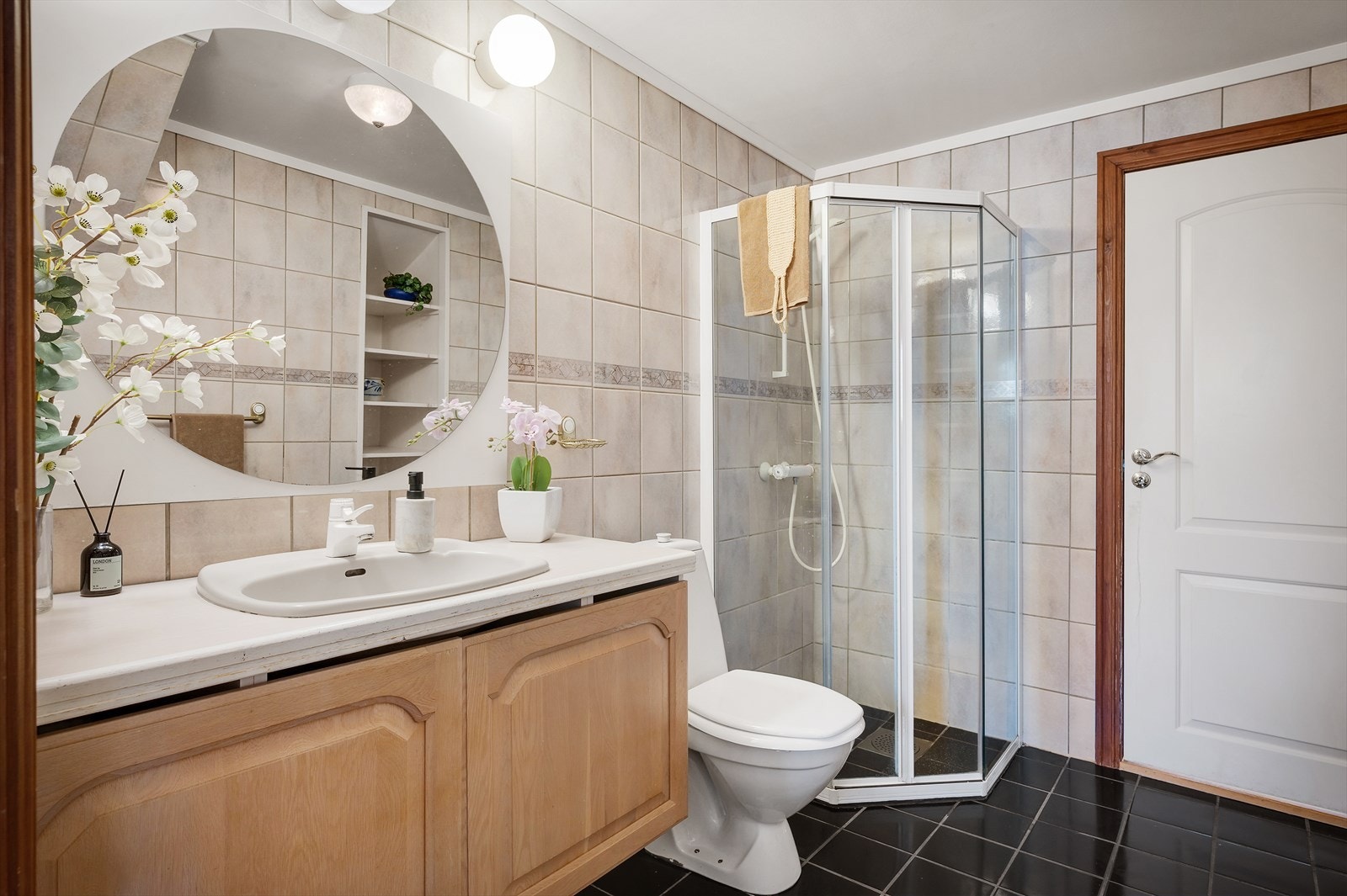 Helfliset bad som inneholder servant i møblement, toalett og dusjhjørne. Galleribilde