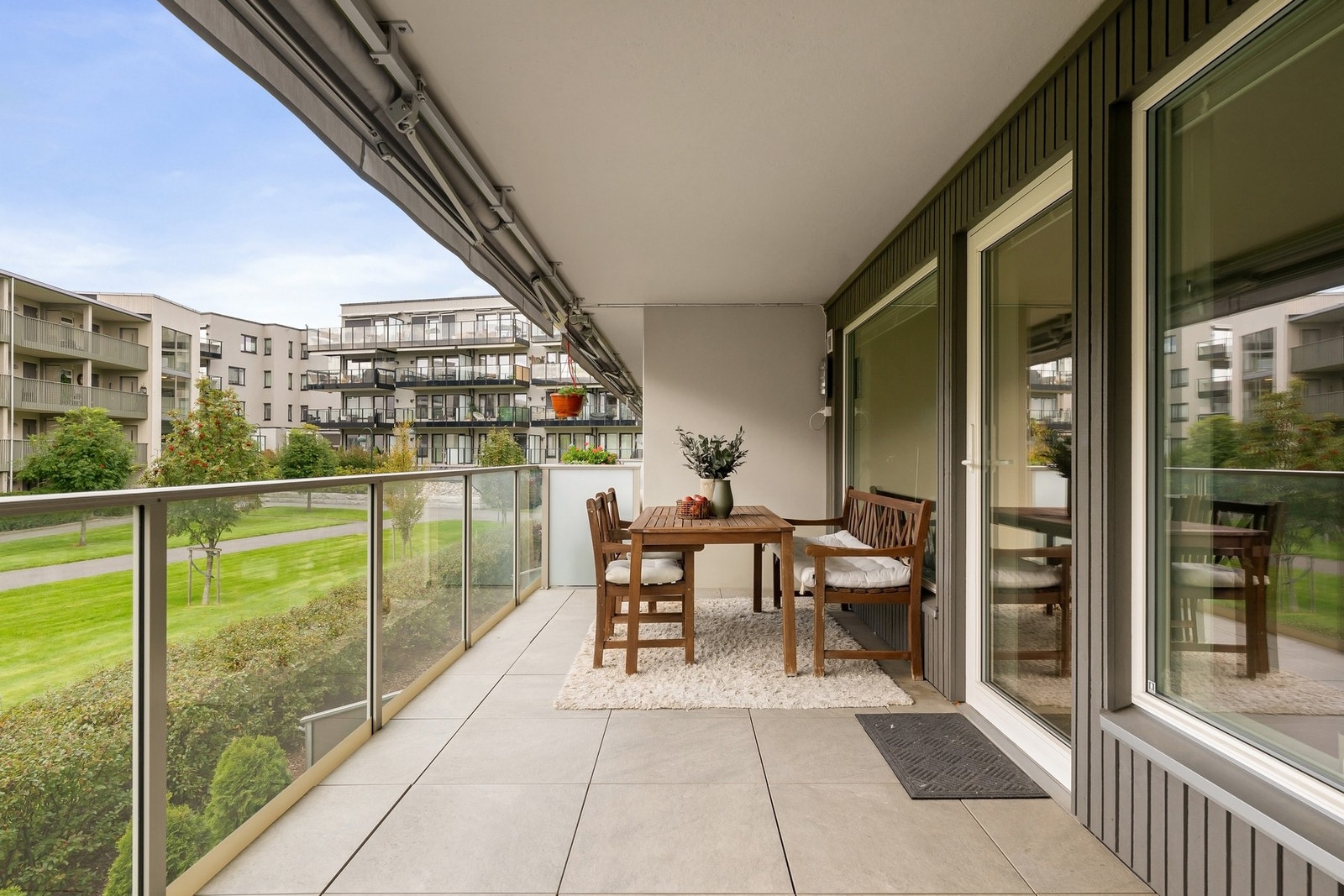 Romslig balkong på 17 kvm med plass til sittegruppe og hyggelig utsikt mot grøntarealer Galleribilde