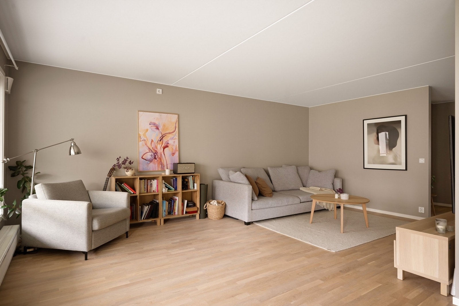 Romslig stue med plass til både sofagruppe og lenestol Galleribilde