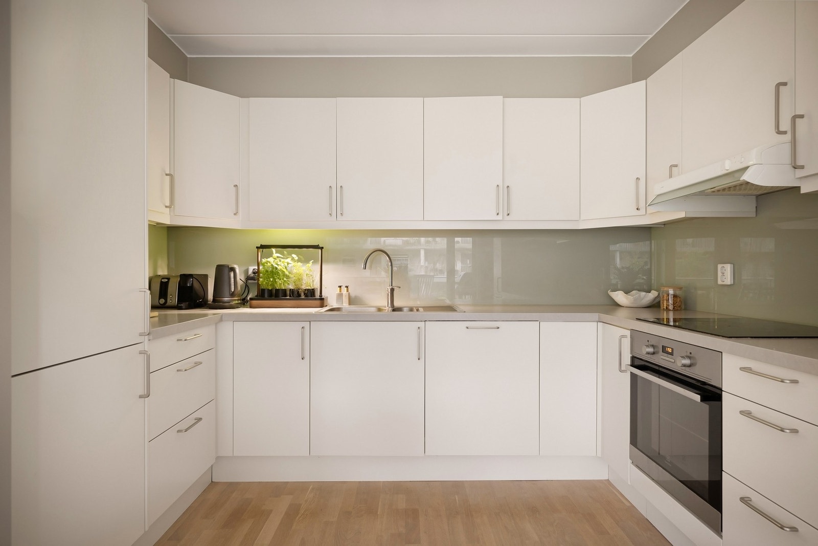 Stilrent kjøkken med hvite fronter og laminert benkeplate Galleribilde