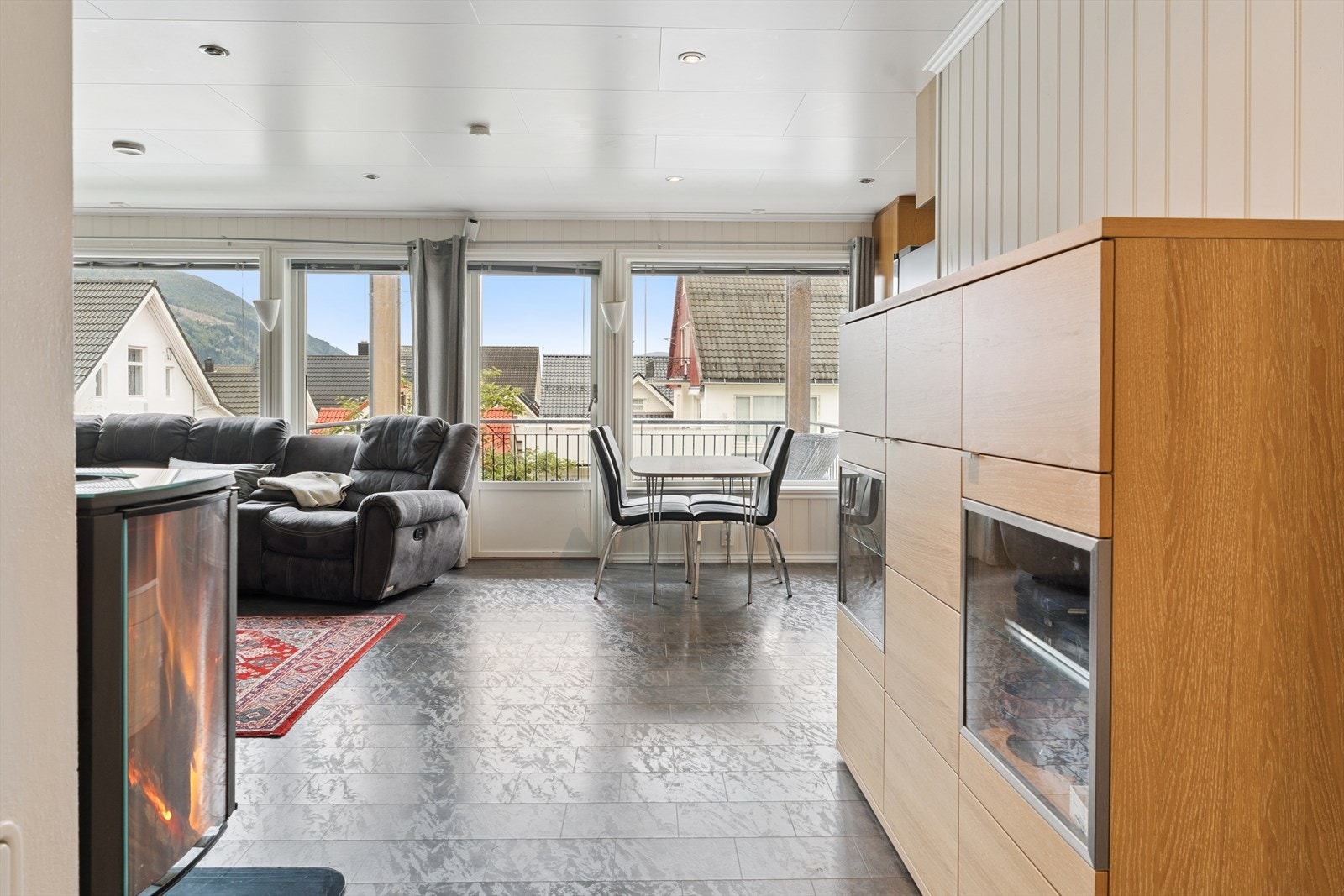 Stove med store vindaugsflater. Lyse veggar og mørkare laminatgolv. Galleribilde