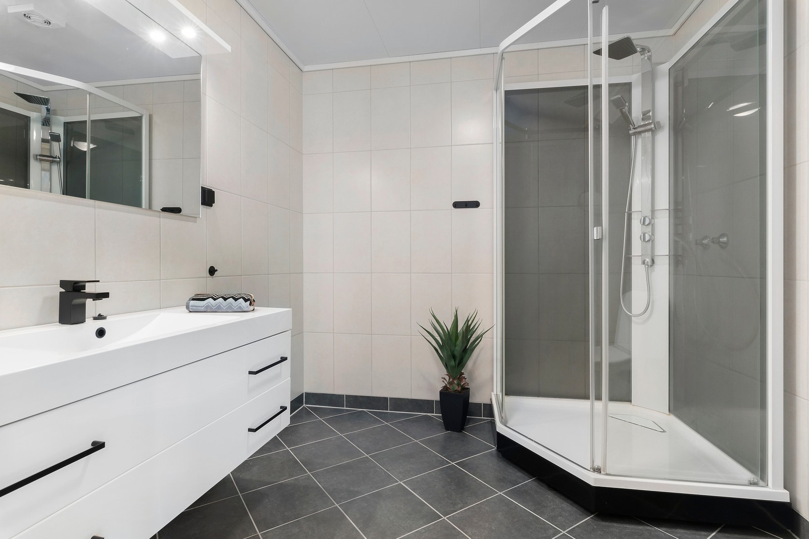 Flislagt bad med varme i gulv og stort dusjkabinett. Galleribilde