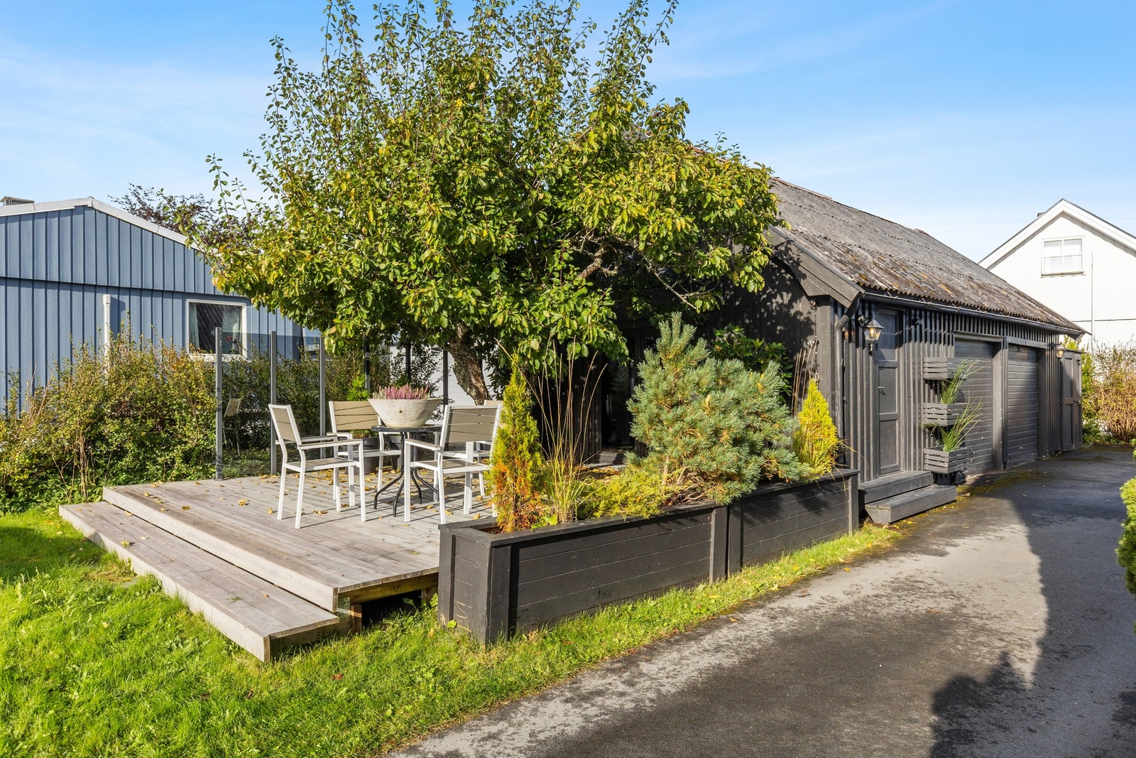 Garasje med to leddporter i tre. Praktisk bod i garasje for oppbevaring. Galleribilde