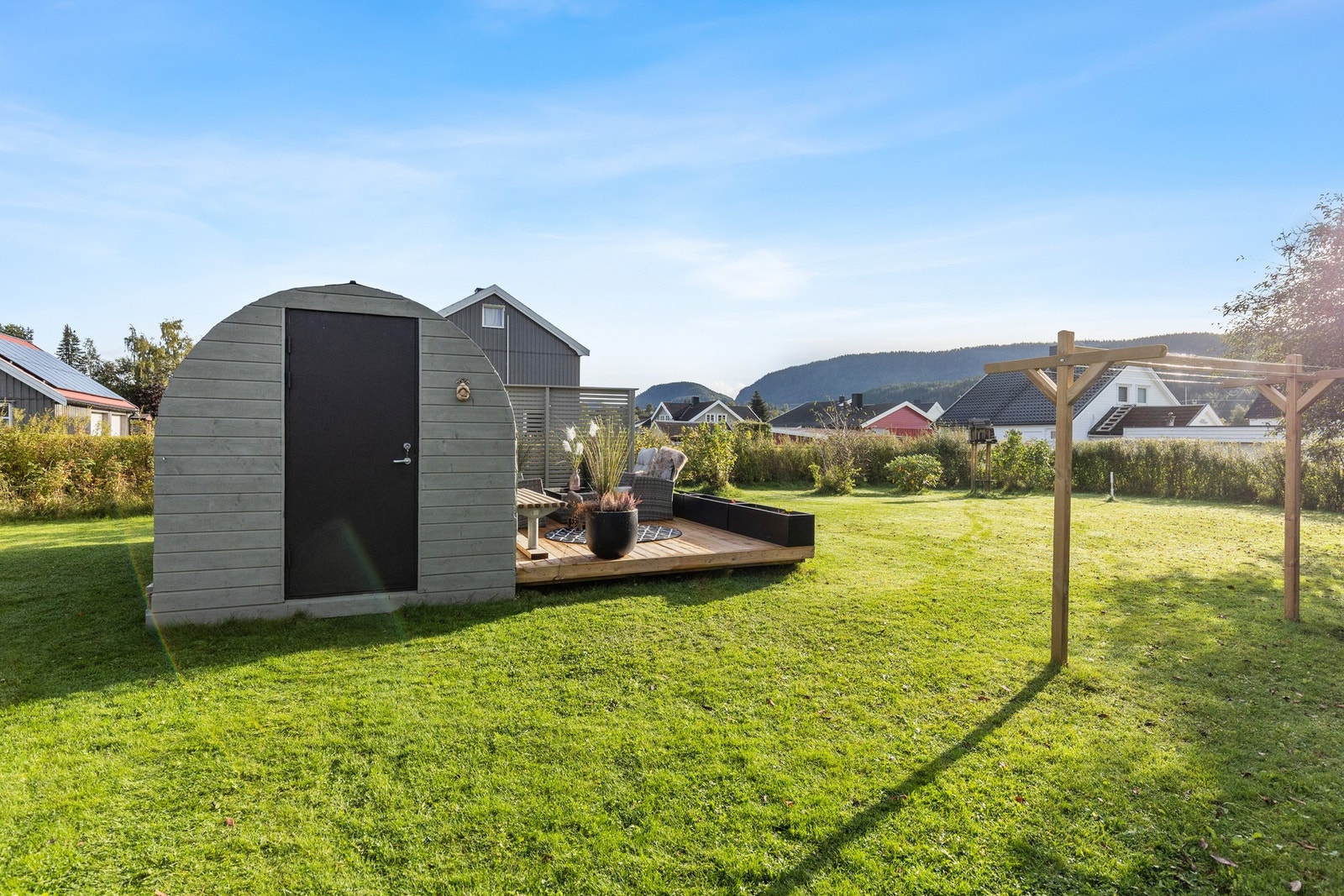 Bod i hage med buet tak kledd med liggende panel. Galleribilde