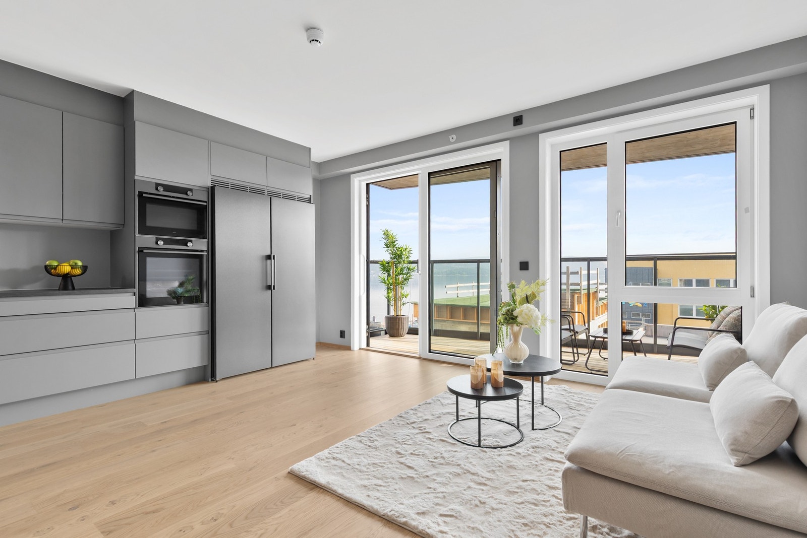 Lys og pen stue med 1-stavs parkett på gulv og store vinduer som gir en luftig romfølelse Galleribilde