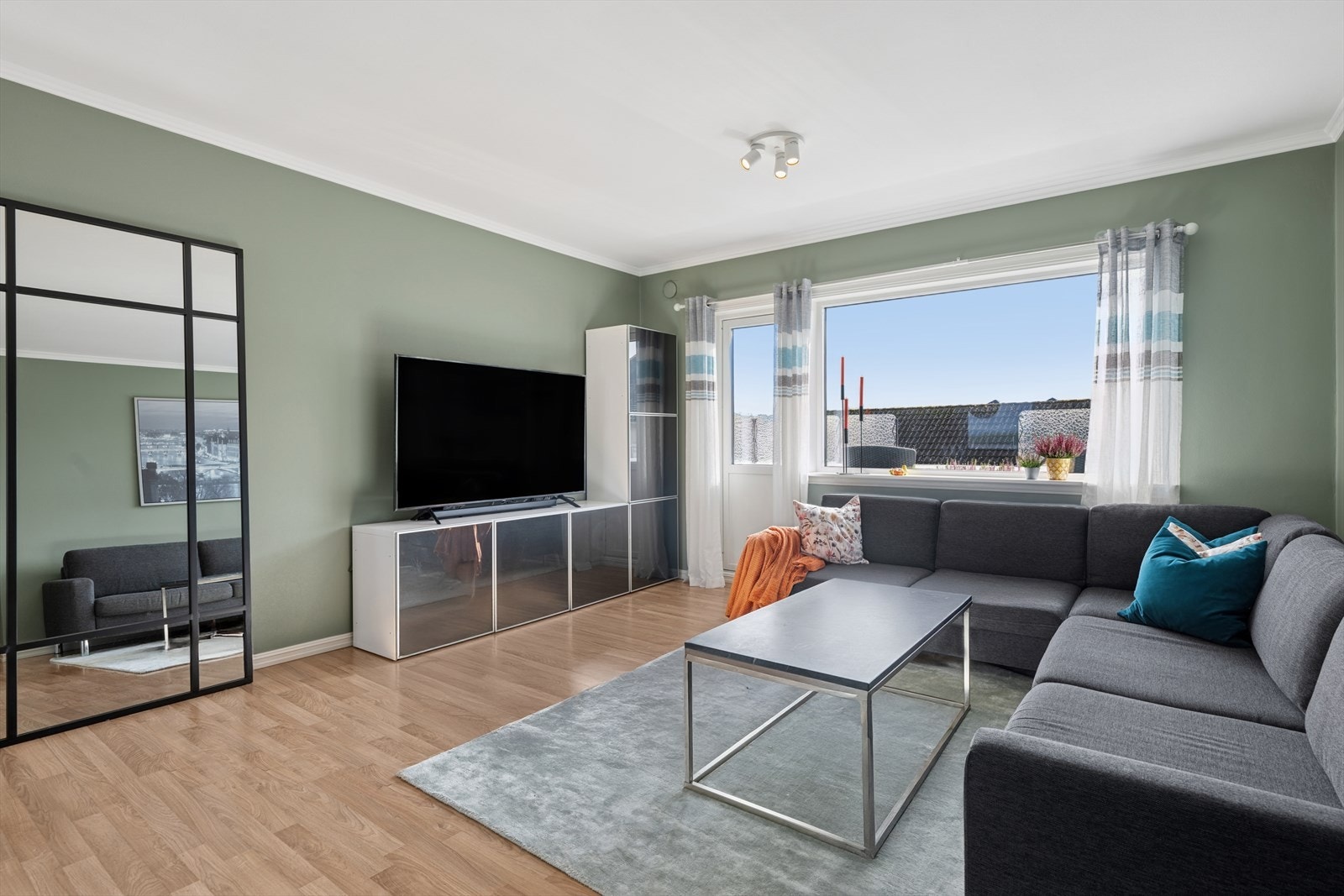 Stuen har store vindusflater som slipper inn rikelig med dagslys og skaper en lys og luftig atmosfære. Galleribilde