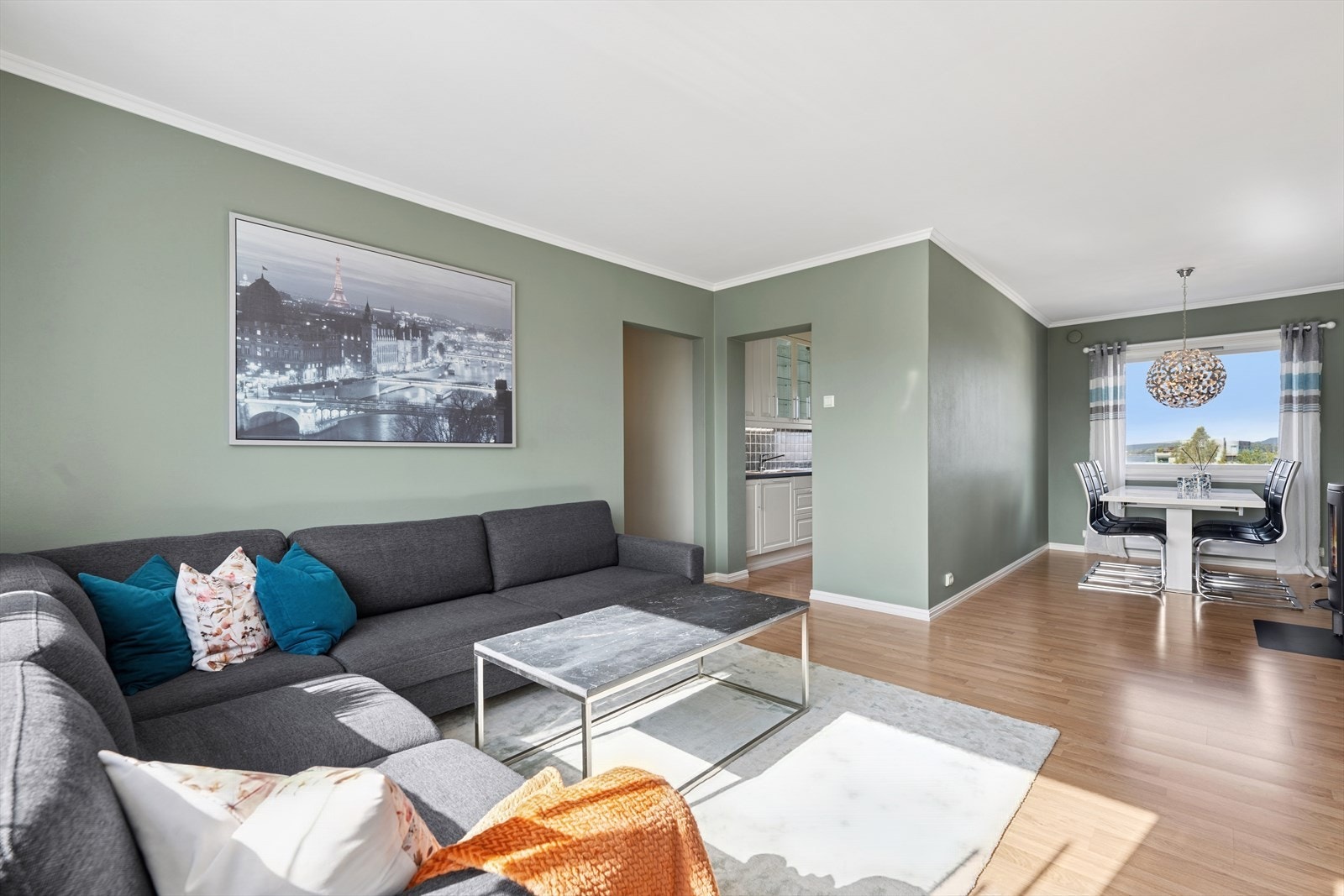 Videre inn i leiligheten kommer du til et avdelt kjøkken med pen innredning, og en romslig stue med plass til både tv-stue og spisestue Galleribilde