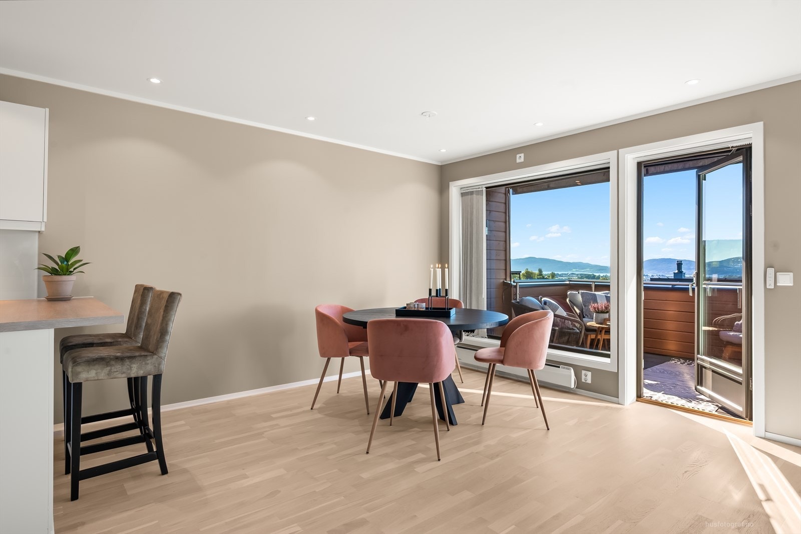 Boligen har en åpen løsning mot kjøkkenet, adskilt med kjøkkenøy, noe som bidrar til at rommet føles som et sosialt allrom. Galleribilde