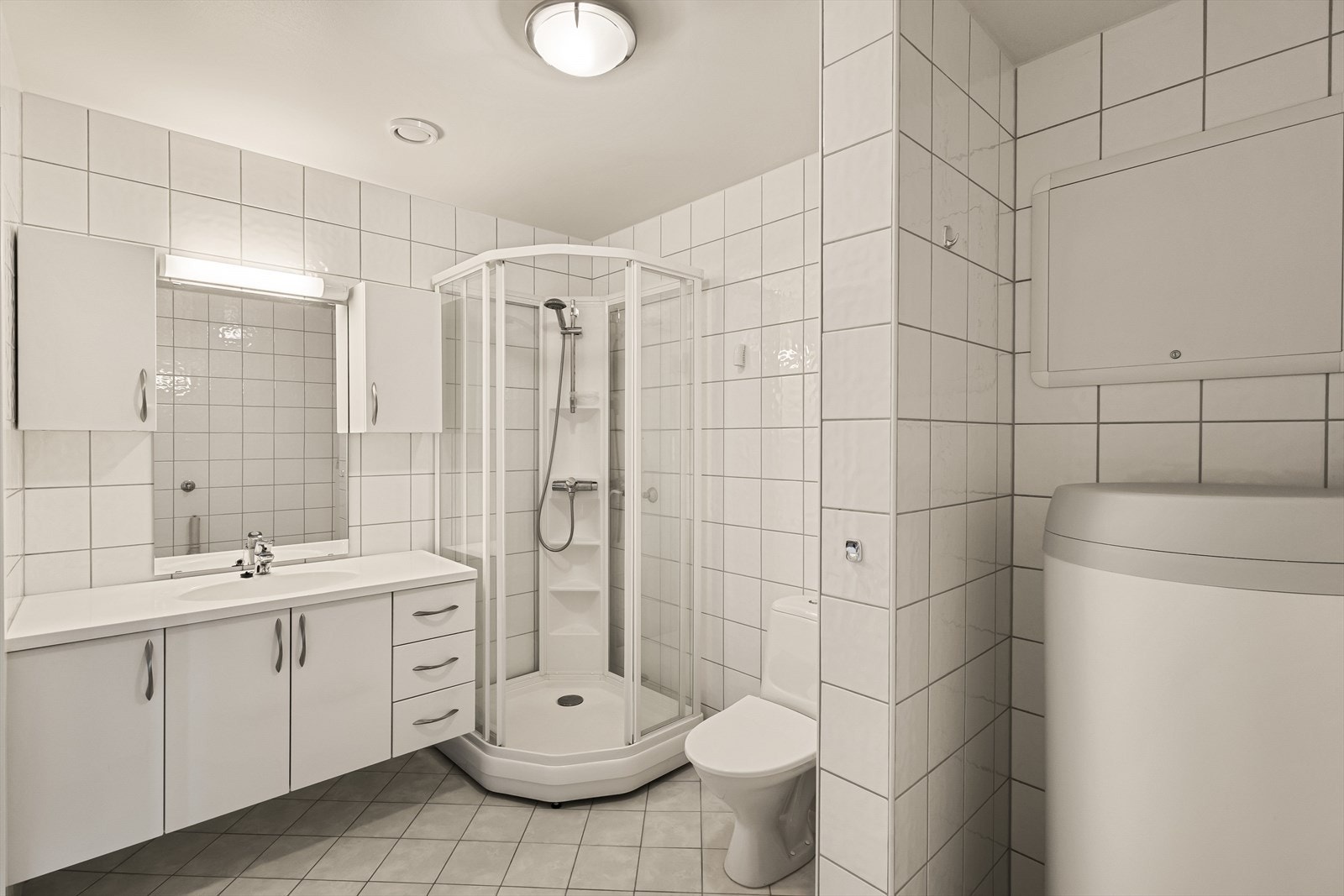 Badet er innredet med servant, møblement/speil, toalett, dusjkabinett og opplegg for vaskemaskin. Galleribilde