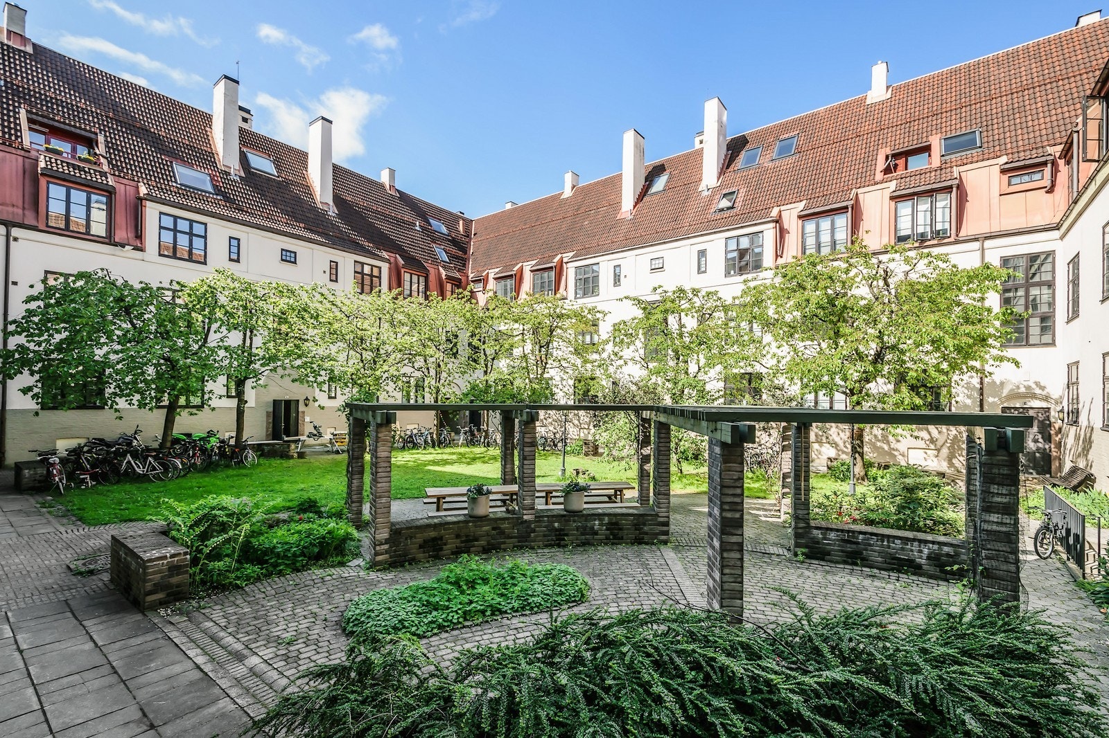 Hyggelig bakggård med sittegrupper og grøntaeraler Galleribilde